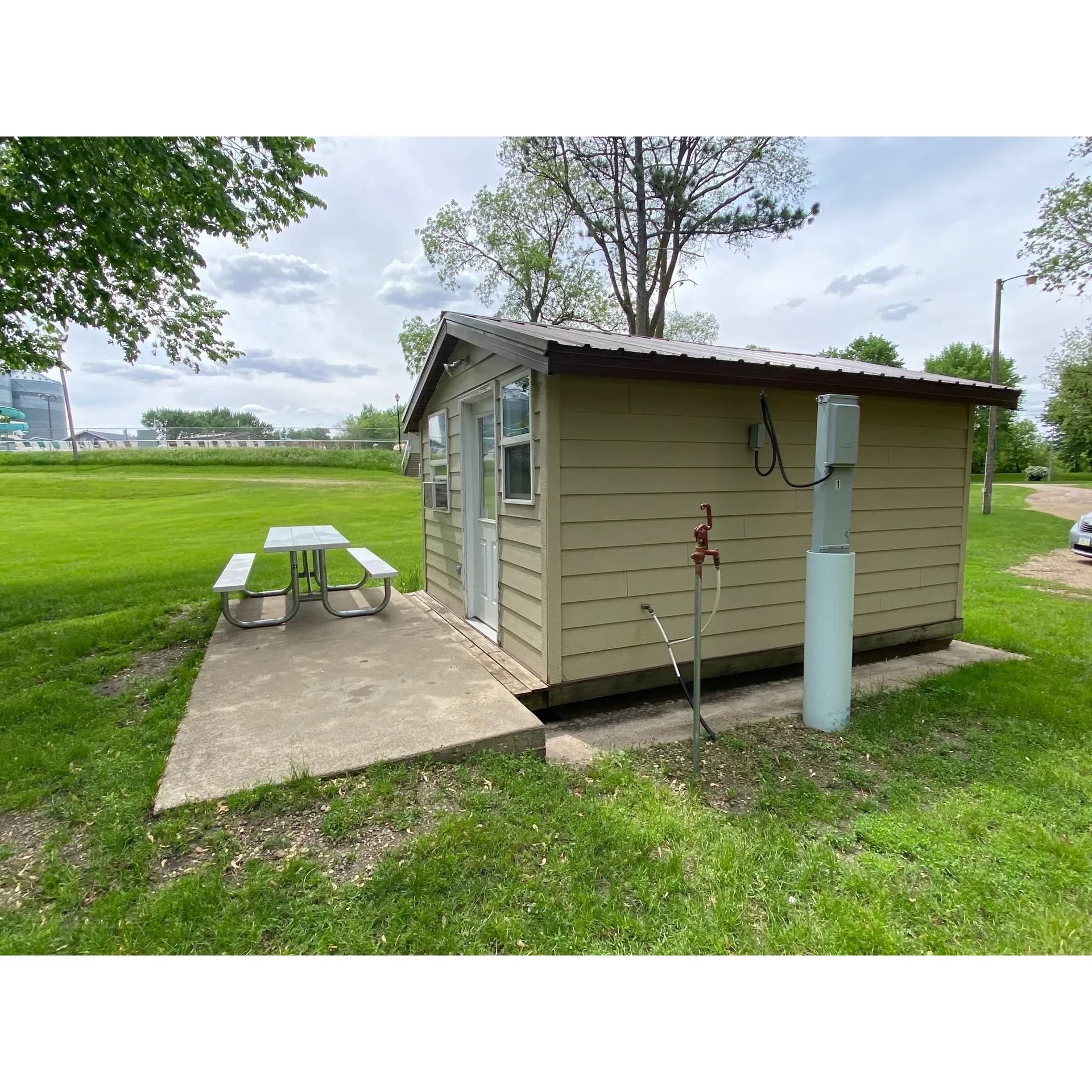 Island Park Campground offers an idyllic escape into the serenity of the great outdoors. Picture yourself settled into one of the charming cabins available for rent, providing a cozy retreat for families, friends, or couples. The natural beauty of the surrounding area is highlighted by the gentle curves of a nearby oxbow stream, perfect for children to splash and play in while ensuring peace of mind with its reassuring shallowness.

The campground doesn't skimp on amenities either, boasting delightful playgrounds for the little ones to burn off energy, along with an inviting outdoor pool to cool off on those warm sunny days. For those seeking a quiet moment, the lush canopy of shade trees creates a tranquil environment for relaxation and respite.

Activities abound for all age groups and interests. Whether you're interested in casting a line in the neighboring river, roasting marshmallows by a crackling fire, or taking a leisurely stroll along the paved walking trails that accommodate wheelchairs and strollers alike, there's something here to enrich every visitor's experience.

Facilities are top-notch with a new shelter house for gatherings, impeccably maintained showers and restrooms that offer both privacy and comfort, and water pressure that ensures a refreshing clean. Island Park Campground is not just an accommodation but a retreat that blends affordability with the splendors of the natural world, offering a picturesque setting for creating lasting memories. Description by ChatGPT.