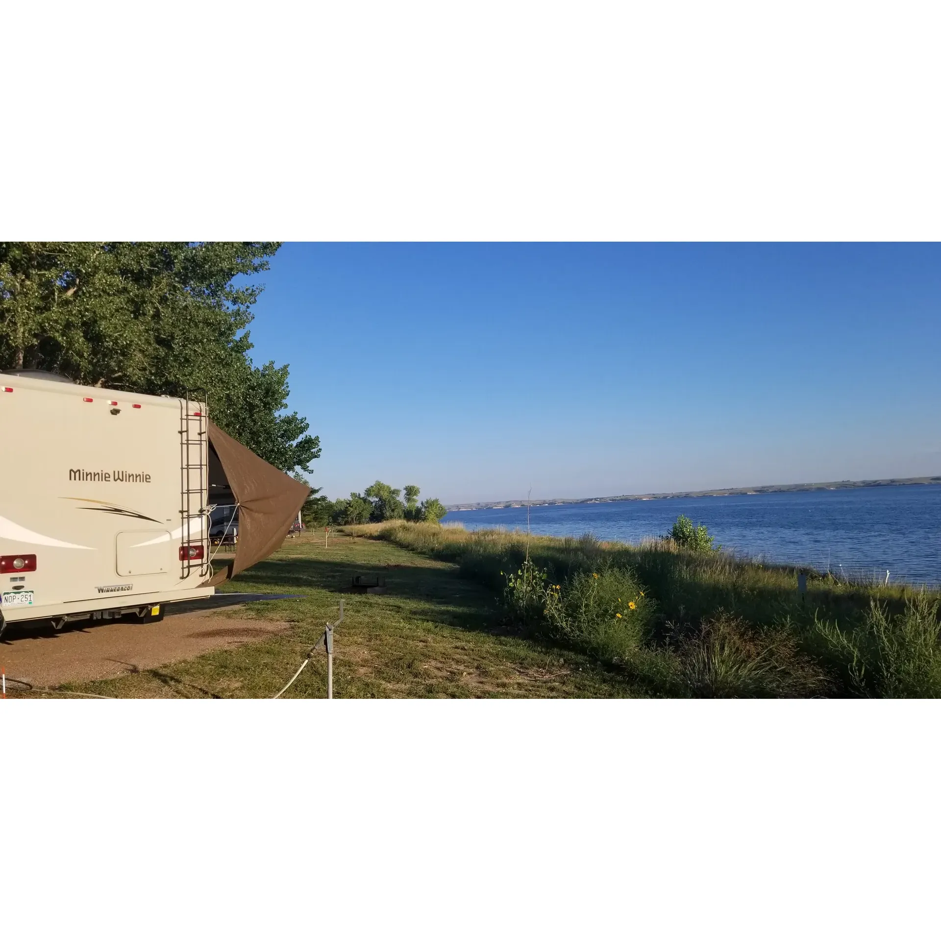 Sandy Beach Campground is a serene family-friendly destination that offers travelers a harmonious blend of outdoor adventure and relaxation. The campground boasts a well-maintained environment that consistently impresses with its cleanliness and welcoming atmosphere. Perfect for family outings and returning visitors, the site has become a favorite for those seeking a familiar retreat.

Guests revel in the opportunity to set up camp along the scenic tree line, where the rustling leaves provide a pleasant, natural soundtrack to an unforgettable camping experience. Each day presents the chance to meander from the shaded canopy of the campsite to the sun-soaked shoreline, engaging in a seamless transition from restful tranquility to beachside excitement. The sprawling beach provides ample space to bask in the warm embrace of the sun and delight in the cooling waters of the beautiful adjacent lake. While the water may be brisk, it offers a refreshing escape during those bright and sunny days.

The campground is also well-equipped to accommodate a variety of camping styles, with the option to secure a spot on the beach particularly appealing to those traveling in RVs. Moreover, Sandy Beach Campground takes pride in ensuring all visitors have a stress-free experience, offering complimentary services to assist guests with specific needs, such as vehicles that might otherwise find the sandy terrain challenging.

After the day's adventures, the campground transitions into a peaceful haven as the evening's quiet policies take effect. This respectful culture ensures that all guests can enjoy the serene environment and starlit skies without disruption. Natural beauty envelops the area, as campers find themselves surrounded by lush trees that evoke a sense of exotic escapism, all without leaving the heartland.

Whether it's for a single night or a multi-week stay, Sandy Beach Campground offers a picturesque lakeside setting that promises great times with family and friends, and a truly memorable outdoor experience. Description by ChatGPT.