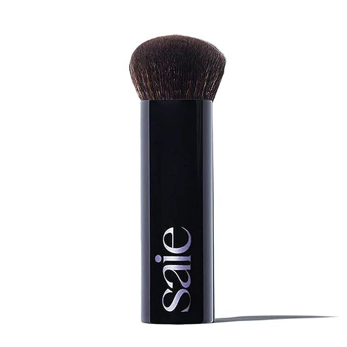 Step up your makeup game with the cutting-edge precision of Saie's The Big Buffing Bronzer Brush. Its plush synthetic bristles are tightly bound to pick up the perfect amount of product, ensuring even distribution for a smooth, streak-free bronze. Developed with the contours of your face in mind, the large, dome-shaped head glides effortlessly over every angle—cheeks, forehead, and jawline are effortlessly sculpted. Whether you're an amateur or a pro, its ergonomic handle fits comfortably in your hand, giving you control for unparalleled results.