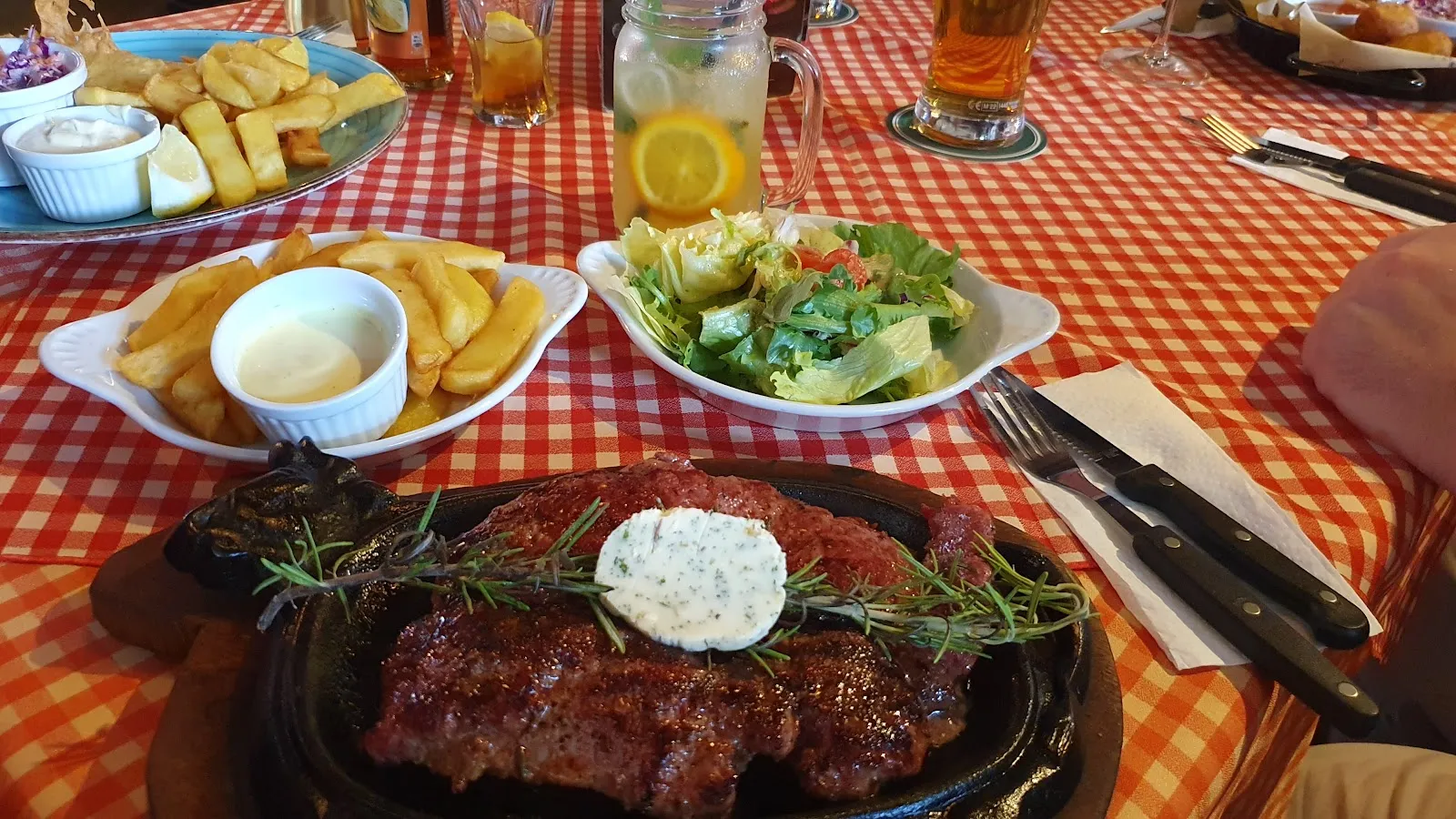 With walls adorned in numerous pictures, the ambiance upstairs adds to the dining experience, especially with a selection of well-received starters such as wings, calamari with sweet potato fries, and a notably well-prepared steak tartar. While the main courses, like the burger and Texas steak, generally receive good remarks, the occasional misstep—such as the Angus steak not hitting the mark in terms of flavor—is promptly and professionally addressed by attentive service staff.