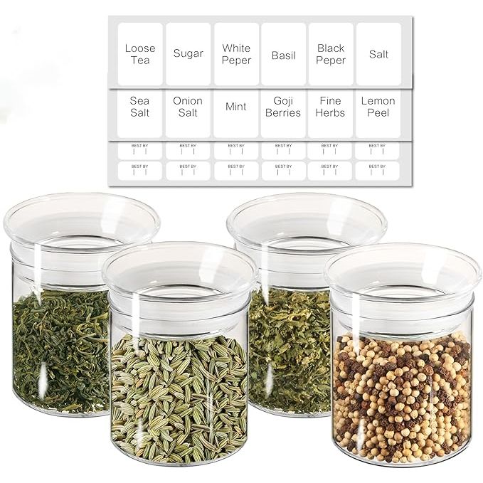 The ZENS Glass Canister Set is a set of four small airtight kitchen storage jars with glass lids. These clear containers have a 10oz capacity, making them perfect for storing spices, herbs, and other dry goods. Each jar comes with labels and stickers for easy identification of contents.