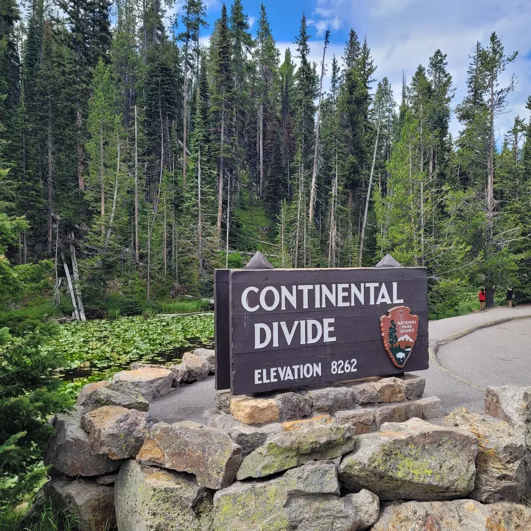 Continental Divide stands as an extraordinary landmark and an essential photo opportunity for travelers exploring the breathtaking expanse of Yellowstone. Recognized as one of three Continental Divides within the park, it uniquely graces the shores of Lake Isa, offering visitors a remarkable natural phenomenon and a serene atmosphere. 

Easy to access, this picturesque location is complemented by convenient parking, ensuring it fits seamlessly into your Yellowstone itinerary without the hassle. Visitors are drawn to the spot for its tranquility and the uniqueness of Lake Isa, which intriguingly empties into two distinct oceans in a geological oddity that fascinates and educates.

Whether on a leisurely Wednesday afternoon drive or as a planned destination, it’s an inviting detour for those threading through the park’s wonders. This cool lure of nature is a must-see, providing an unforgettable backdrop that enriches your Yellowstone experience. It’s a beautiful stop that promises a moment of reflection at the crossroads of the continent, where you can immerse in the beauty and proudly declare, "I was there." Description by ChatGPT.