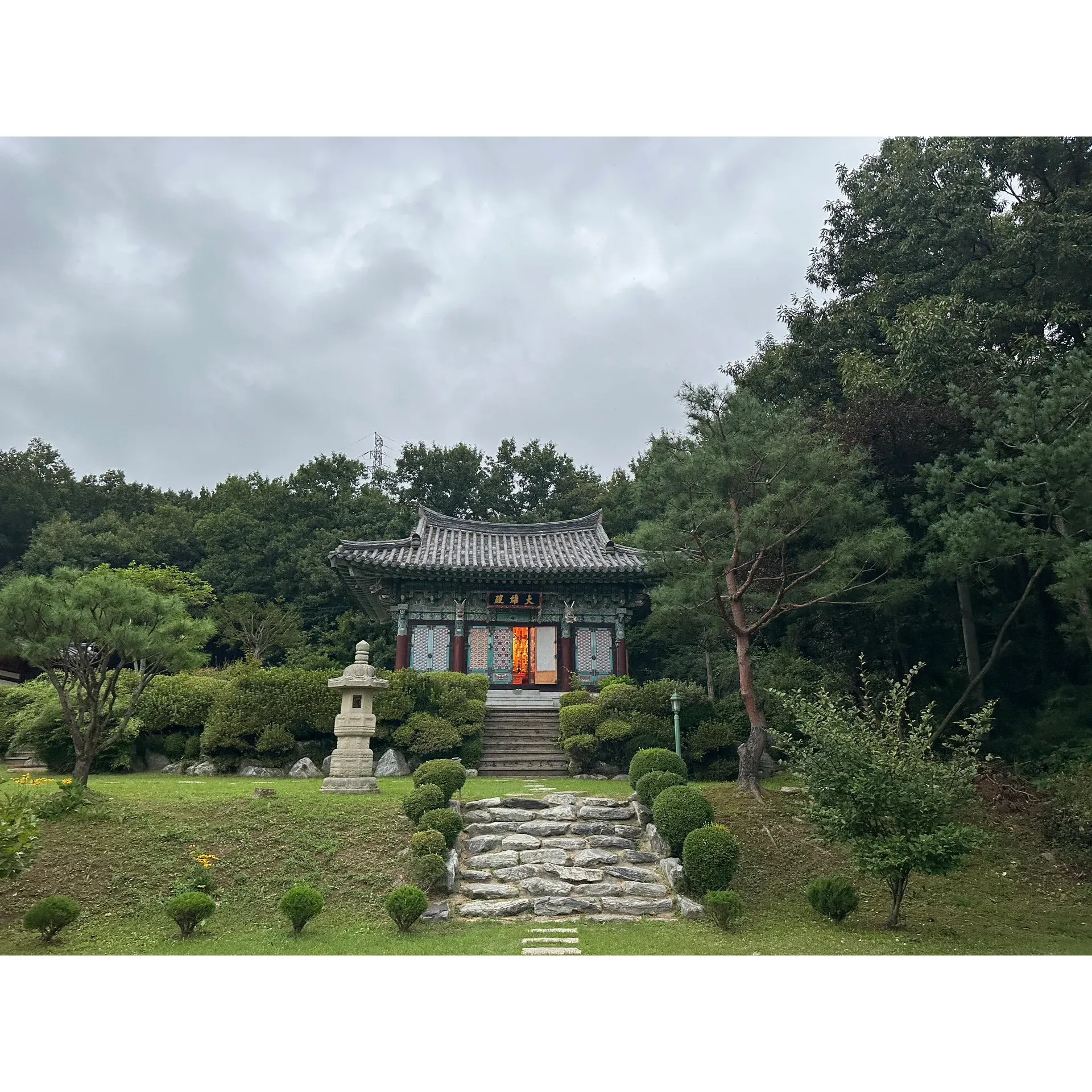 Discover tranquility and spiritual enrichment at the Lotus Lantern International Meditation Center, a serene oasis for those seeking to delve into Buddhist practices amidst the peaceful embrace of nature. This revered center, a treasured location for practitioners and visitors, is a destination for mindfulness and learning. It offers an opportunity to withdraw from the commotion of urban life and immerse oneself in an eco-friendly environment where the presence of frolicking animals and vibrant insect life adds to the center's charm.

Lotus Lantern is an exceptional haven for understanding the depth and breadth of Buddhist thought, providing unique insights into the differences between Mahayana and Hinayana Buddhism. The leadership of a chief monk, whose spiritual journey traversed from India to the Korean Buddhist Sangha, brings an authentic and diverse perspective to the teachings and practices housed within the center.

Participants often describe their stay at Lotus Lantern as a transformative experience, highlighting the friendliness and wisdom of the monks and community members. Here, learning transcends the theoretical, offering practical wisdom that integrates seamlessly into daily life. The offerings include a variety of activities, such as early morning ceremonies, calligraphy, the rhythmical playing of the moktak instrument, and the contemplative challenge of 108 prostrations.

Alongside rigorous spiritual practices, guests can enjoy quiet moments of reflection during walking meditations through the surrounding landscapes, where they may encounter historical artifacts like a scholar's tomb from an ancient dynasty, as well as nature's own, like a sun-bathed snake weaving through a forest trail.

Despite its less-than-convenient location, Lotus Lantern ensures accessibility through a thoughtful shuttle service that connects guests from the nearest bus terminal to the heart of the center's peaceful setting. Accommodations are clean and properly equipped with modern amenities such as air conditioning and fresh bedding, maintaining the simplicity and authenticity characteristic of temple stays.

This beautiful meditation retreat not only stands as a bastion of peace and natural beauty but also as a multicultural nexus where language is no barrier. Monks and devotees facilitate a warm and welcoming environment, with proficiency in English, Korean, and various Indian languages, ensuring that every guest feels comfortable and valued.

With an invitation to dive into a world of meditation and mindfulness, the Lotus Lantern International Meditation Center stands out as a beacon of tranquility and spiritual discovery, inviting all who seek personal growth and peace. Description by ChatGPT.