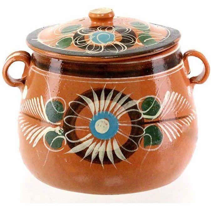 The New Olla De Barro Frijolera w/Lid 3.5 Quarts Canterito Cazuela is a traditional Mexican clay pot made of high-quality terracotta. It features a beautiful floral design on both the pot and the lid, adding a touch of elegance to your kitchen.