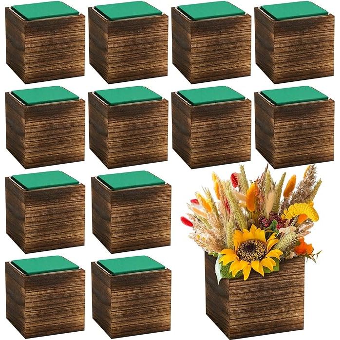 The 12 Set Wood Cube Planter Box is a set of rustic wooden vases that are ideal for decorating your home, wedding, or garden. Each square wood vase comes with a removable plastic liner, making it easy to add water and keep your flowers fresh. The brown color and country style design add a touch of charm and warmth to any space.