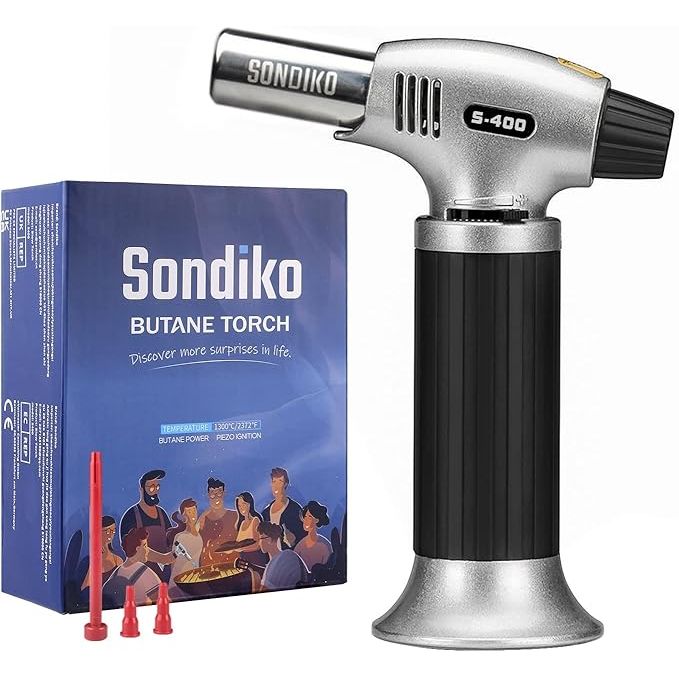 The Sondiko Butane Torch S400 is a versatile kitchen tool that is perfect for creating delicious desserts such as creme brulee, melting cheese, roasting peppers, and more. This refillable butane torch features a safety lock to prevent accidents and burns, as well as an adjustable flame for precise control when cooking or baking.