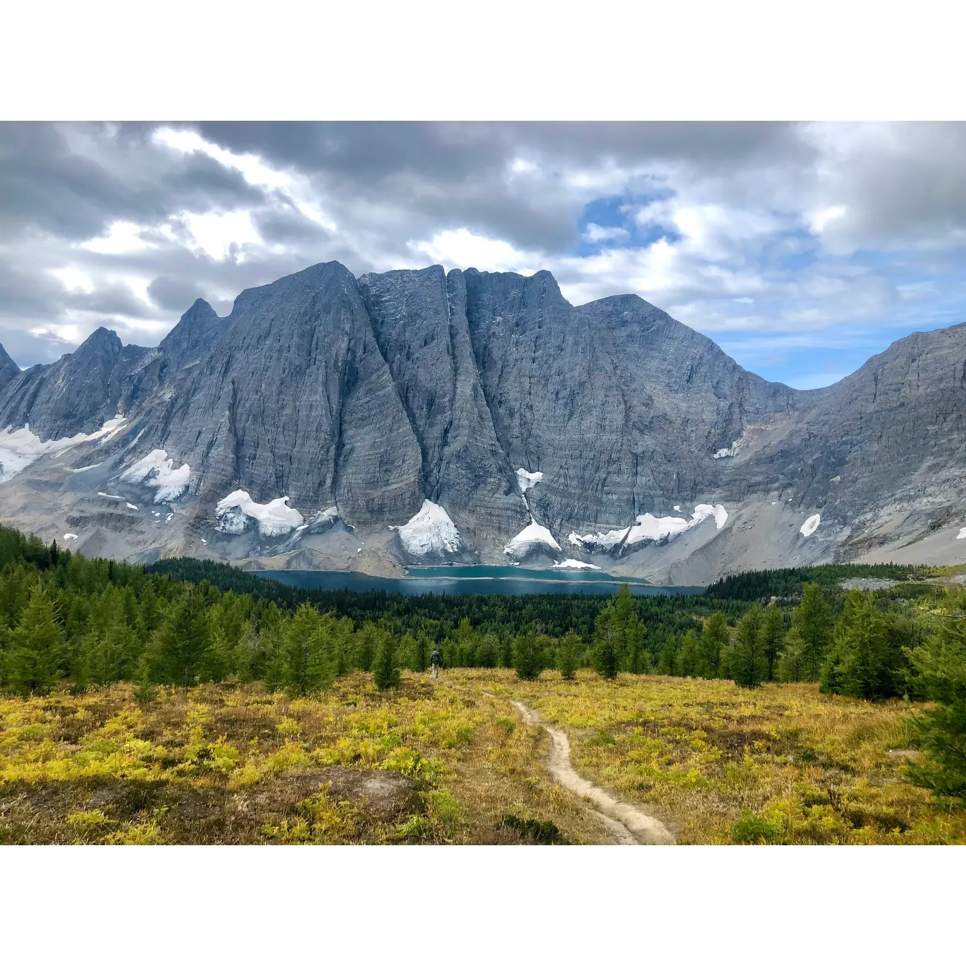 Floe Lake is a breathtaking destination that serves as a crowning jewel for hikers traversing the renowned Rockwall Trail. This picturesque spot offers a serene retreat for outdoor enthusiasts looking to immerse themselves in nature. With its vibrant blue waters and panoramic views, the lake provides an idyllic background for campers who spend their nights at well-appointed campsites featuring stunning lake vistas.

Accessed by a trail adorned with wildflowers in full bloom, Floe Lake becomes a rewarding conclusion to an exhilarating journey. The surrounding landscape offers a unique blend of rugged beauty with snow-dusted mountains and rich fall colors, complementing the fine camping experience. For visitors, the warden's cabin serves as a convenient refuge, offering a sheltered deck where travelers can cook and engage in leisurely activities like card playing, all while staying protected from the elements.

Despite the challenging ascent, marked by switchbacks that test the mettle of even the most prepared hiker, the campsite at Floe Lake gratifies with its thoughtfully arranged tent pads and picnic areas. Exploring beyond the immediate vicinity of the lake uncovers even more stunning vistas, with places like Numa Pass providing unforgettable panoramic views.

Floe Lake is not only a site for tranquility and natural beauty but also an adventurer's playground, boasting bountiful late-season raspberries that sweeten the journey. It is a must-visit destination for avid hikers seeking an experience that encapsulates the grandeur of the Canadian Rockies. Whether for a multi-day excursion or a day trip for the vigorously inclined, Floe Lake promises an enchanting and rewarding alpine adventure. Description by ChatGPT.