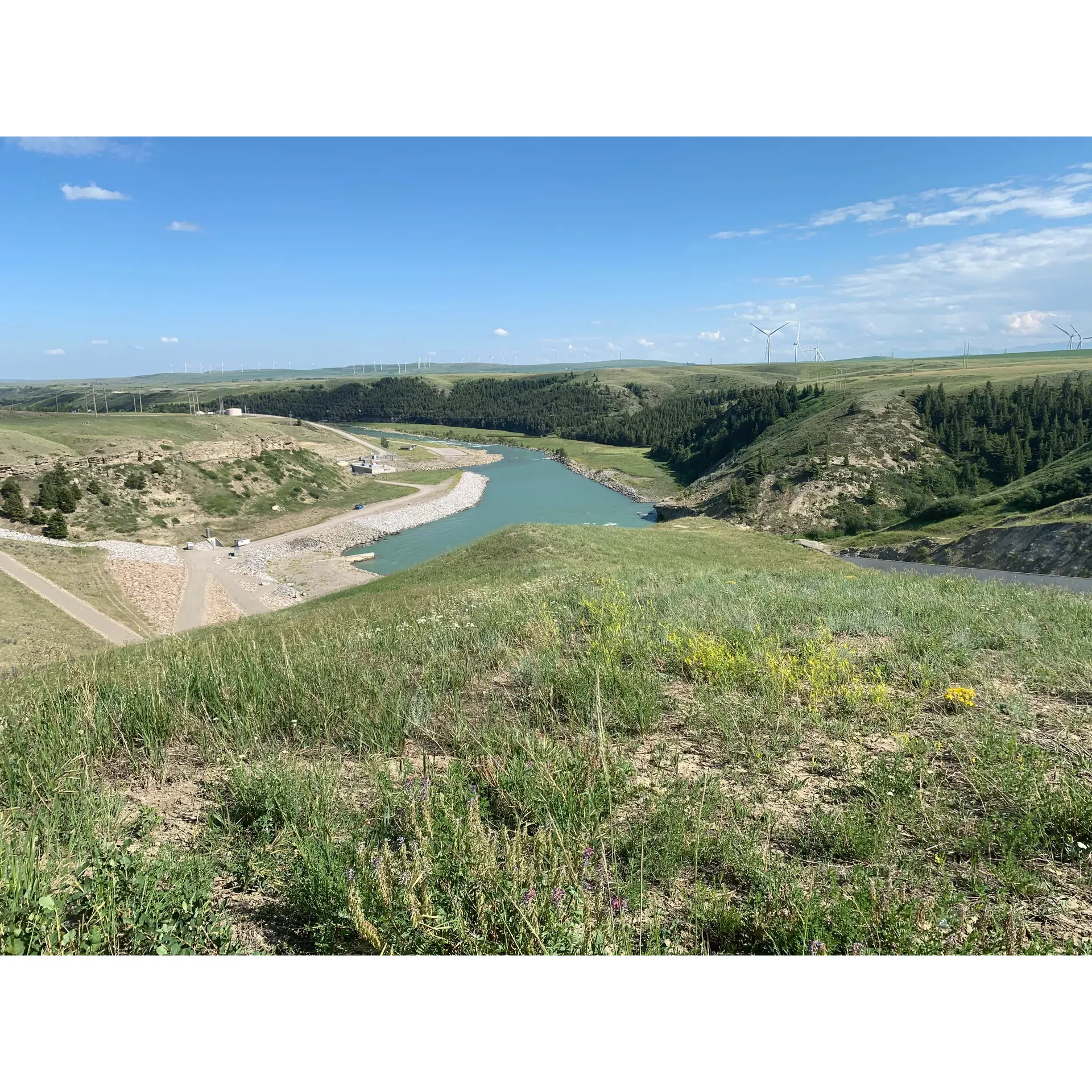 Set against the backdrop of impressive landscapes, Oldman Dam Provincial Recreation Area offers a refreshing retreat with the colossal reservoir offering a panoramic expanse of water ideal for those looking to immerse themselves in nature on a grand scale. Its convenient location, just a short, scenic drive down river from the operational dam, provides visitors with an opportunity to marvel at the engineering prowess and the natural beauty that surrounds it.

The recreation area boasts a well-planned campground that caters to visitors' need for comfort and convenience, with thoughtfully arranged sites that encourage the enjoyment of tranquil mornings and serene evenings. The layout is particularly considerable for RV travelers, advising spots where awnings can open to the east to shield from the region's noted western gusts.

Visitors seeking an escape from the digital world will find solaces here, as the absence of cell service within the campground allows for an unplugged experience, fostering a deeper connection with the environment. Those who need to reconnect, however, have easy access to a signal with just a brief drive up the hill, where the necessary amenities, including a reliable RV dump station, are also positioned for ease of access.

Awe-inspiring scenery around the area sets a dramatic stage for an early morning hike or a moment of reflection at the dam, with historical interests adding a layer of depth to the regional narrative. The reflective aura of the destination is deepened by quiet nights that offer a peaceful ambiance for visitors to unwind after a day of adventure.

For the more practical concerns, facilities such as washrooms maintain a level of standards that meet the expectations of many, while wood delivery for fires adds a touch of convenience and comfort, although catching the delivery requires a bit of timing. Campers are advised to secure their tents well, as the area is known for its robust winds, which nevertheless contribute to the serene mornings and the absence of bugs, allowing for an undisturbed outdoor experience.

In all, the Oldman Dam Provincial Recreation Area presents a straightforward camping experience with direct lake access, where the majesty of the natural surrounds and the simple pleasure of a quiet campsite come together to provide a memorable backdrop for travelers passing through or seeking a restful stay. Description by ChatGPT.