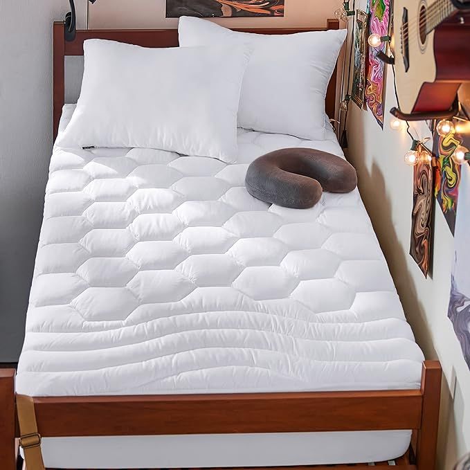 Upgrade your stiff dorm room mattress with the Bedsure twin XL mattress pad. Made of 100% polyester with an ergonomic three-zone design, this mattress pad features a softer wavy top and bottom zone for improved relaxation, and a honeycomb-shaped middle quilting for evenly distributed support.