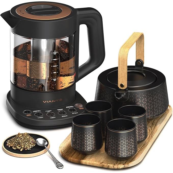 The Vianté Luxury Tea Set is a high-quality electric kettle with a built-in tea infuser designed for loose leaf tea. This set includes a beautifully crafted ceramic serving set, with a tea pot and cups, all displayed on a stylish wooden tray.