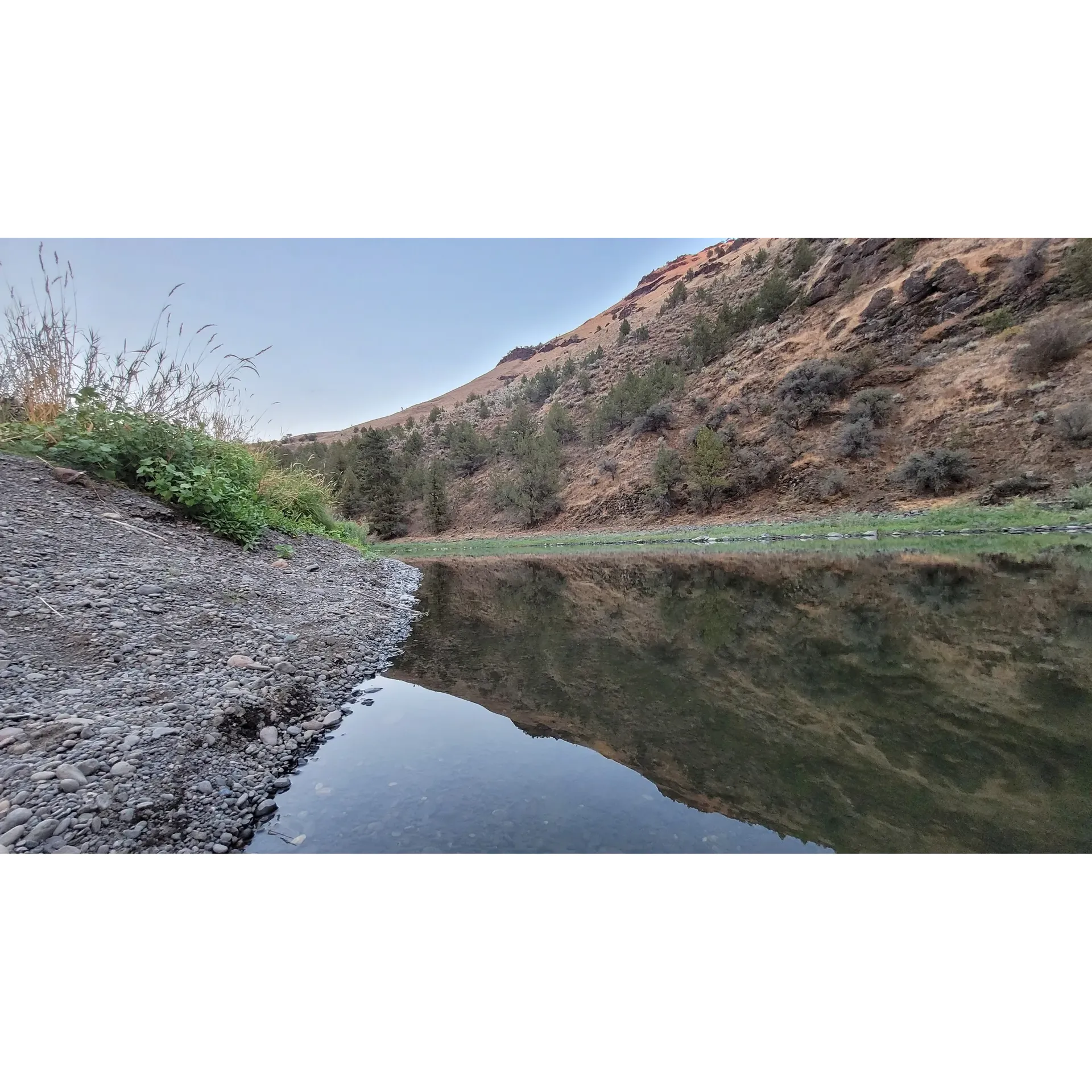 Big Bend Campground is an undiscovered gem for outdoor enthusiasts and anglers alike, offering an excellent fishing experience with its abundant bass population. At a rate of just $5 per night, the campground presents an unbeatable value for visitors seeking a peaceful retreat without breaking the bank. Embraced by the serene John Day River, guests are treated to waters at a comfortable temperature perfect for midsummer swimming and exploring the riverbed for interesting rocks.

The site especially caters to RV campers looking for a tranquil escape to nature, with spacious flat sites situated right along the rushing river. The simplicity of the campground provides an authentic back-to-nature vibe, encouraging guests to bring essentials like water and to continue their eco-friendly practices by packing out trash, thereby maintaining the pristine environment.

When the sun goes down, the area transforms into an enchanting riverside haven. To enhance the experience, campers are advised to bring yellow or red lamps to deter the bustling night-time insect life without detracting from the magic of warm summer nights in the wild.

For those visiting in the quieter months, such as early October, Big Bend Campground is particularly appealing for its tranquil ambiance. With its beautiful scenery and clean restroom facilities, guests can appreciate the unspoiled surroundings without the distraction of crowded sites.

The campground's river access points, surrounded by natural stone settings, add another layer of adventure for the more daring, as visitors can wade and interact with the local wildlife, including inquisitive crawdads.

Whether seeking a fishing getaway, a riverside retreat, or simply a serene spot to enjoy the outdoors, Big Bend Campground stands out as a welcoming, affordable, and scenic destination awaiting those who appreciate the great outdoors. Description by ChatGPT.