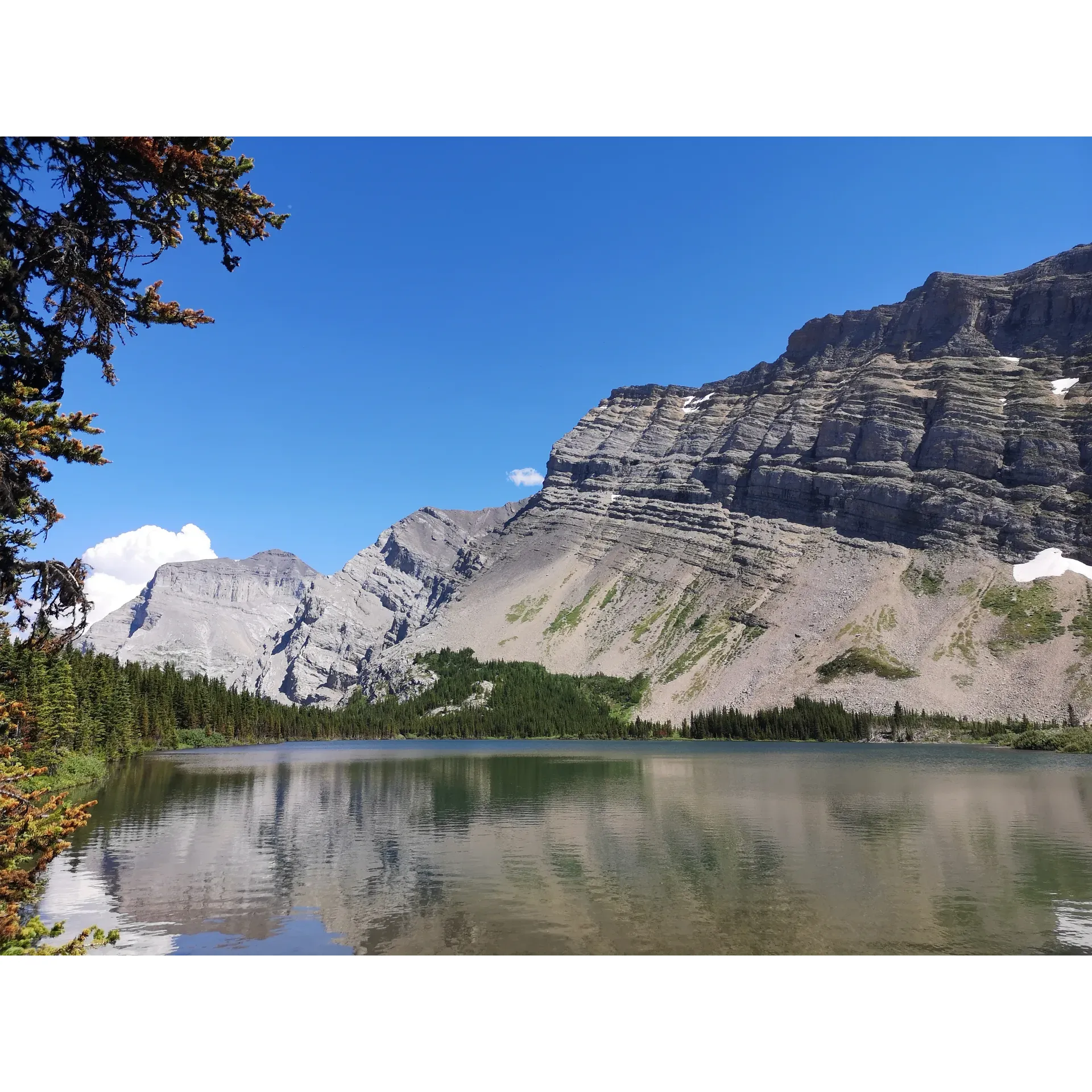 Ribbon Lake offers outdoor enthusiasts a truly spectacular and adventurous experience. The main draw is the exhilarating hiking trail, which features an array of fun elements including iron chains for climbing, adding to the adventure and challenge. The terrain provides a stimulating experience for those looking to engage in an active ascent.

Strategically placed along the trail, a calming waterfall creates an idyllicity that is perfect for a peaceful meal or a moment of relaxation, with a thoughtful addition of a bench inviting hikers to sit and enjoy their lunch amidst natural splendor.

For visitors who prefer a shorter hike, a halfway point is recommended for an easier and equally enjoyable experience, ensuring that the beauty of Ribbon Lake is accessible to hikers of varied endurance levels.

Those seeking to extend their stay will find the campground welcoming, with essential amenities such as a bicycle parking lot adding convenience to the adventure. Despite the likelihood of mud – a natural aspect of the great outdoors – the campground retains its charm and provides a rustic, authentic camping experience.

With a relatively short approach of only 12km, the trail remains popular among day-trippers and campers alike. The pristine turquoise lake itself is a rewarding sight, embraced by the majestic embrace of surrounding mountains. Its crystal-clear waters reflect a serene beauty that is a testament to the untouched wilderness of the area.

For the adventurous spirit, the iron chains and the ascent in various weather conditions are part of what makes the journey to Ribbon Lake an unforgettable one. While the weather can play a role in the trail conditions, the end views are universally acknowledged as completely worth the effort.

A gem within Alberta and indeed Canada, Ribbon Lake is heralded for its breathtaking landscape. Its capacity to blend outdoor adventure with awe-inspiring scenery makes it a must-visit destination for those wishing to immerse themselves in the grandeur of nature. Description by ChatGPT.