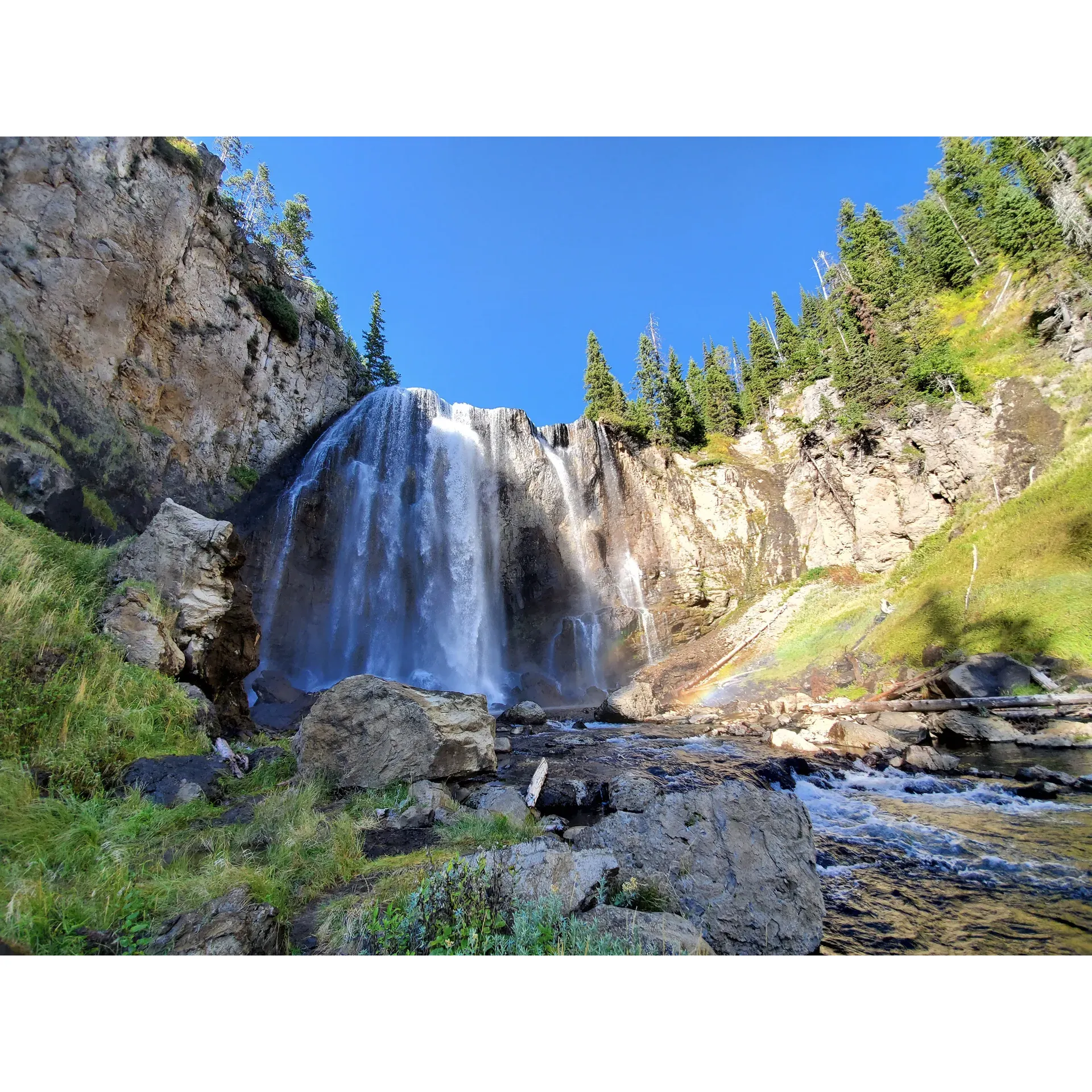 Immerse yourself in the breathtaking splendor of Dunanda Falls, a hidden gem in the heart of Yellowstone National Park. Here, the allure of the wild meets the comfort of relaxation as the majestic waterfall cascades with grace, creating a natural spectacle that captivates the soul. Surrounded by the pristine wilderness, visitors can embark on an adventurous backpacking journey to discover the serene beauty that awaits.

Crowned by the awe-inspiring falls, the area also presents a chance to unwind in the therapeutic embrace of natural hot springs. With warm, inviting waters, these springs offer a perfect haven for rejuvenation and tranquility. Dunanda Falls stands as an idyllic retreat for nature enthusiasts and those seeking to find solace away from the hustle of everyday life. The harmonious blend of adventure and peacefulness makes this destination a truly amazing place to explore and cherish. Description by ChatGPT.