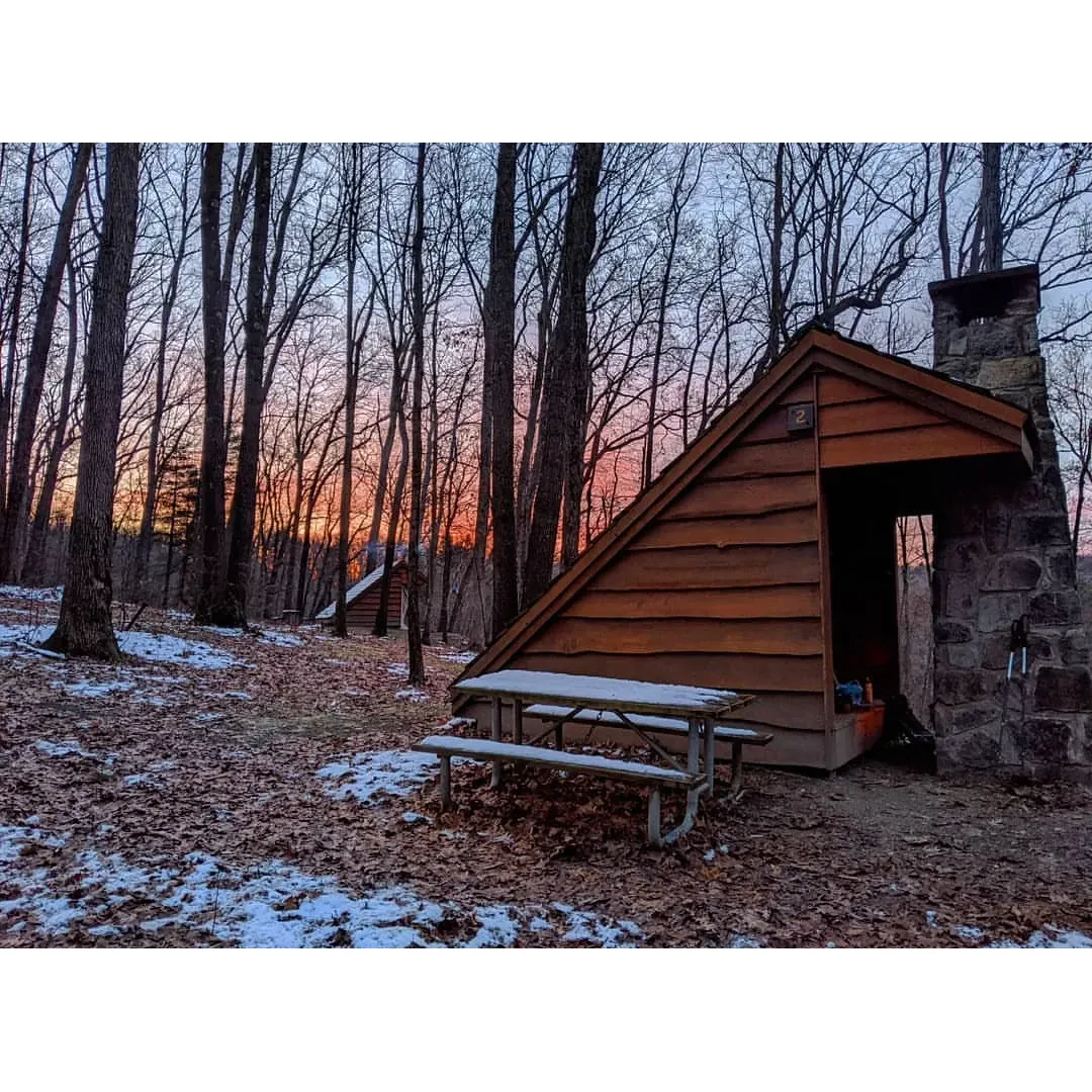 Cow Run Shelters offers an exceptional outdoor experience for enthusiasts seeking both adventure and comfort in the great outdoors. These amazing Adirondack style shelters provide an idyllic retreat for campers exploring the scenic Oil Creek trail. With a ready supply of firewood, visitors are well-equipped to cozy up and enjoy the warmth of a crackling fire, creating a perfect end to a day of hiking and exploration.

Located in a particularly picturesque area that many regard as superior to other spots along the trail, Cow Run Shelters presents a serene setting for nature lovers. The convenient availability of potable water enhances the camping experience, ensuring hydration is readily accessible for most of the year. And for the cold season adventurers, the proximity of streams just a short stroll away offers an alternative for water needs when the chill sets in.

Guests have taken delight in the versatility of the site, as it not only provides sturdy shelters but also includes an area designated for tent camping. This aspect caters to varying preferences, allowing guests to enjoy a tailored outdoor experience. The shelters themselves are celebrated for their impeccable maintenance and the amenity of indoor fireplaces, contributing to a cozy and rustic ambiance.

Families have appreciated the thoughtful provision of public restrooms and a drinking water tank, adding a layer of convenience to the camping experience. The overall setting is complimented by great views and a well-maintained environment that beckons exploration and relaxation.

Cow Run Shelters is a fantastic choice for those looking to create a memory-filled camping trip, with its combination of natural beauty, thoughtful amenities, and the enchanting allure of the wilderness of Oil Creek. Whether for a solitary retreat or a family adventure, Cow Run Shelters provides a harmonious blend of outdoor allure and homey comforts. Description by ChatGPT.