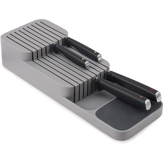The Joseph Joseph DrawerStore Knife Organizer is a compact and efficient way to organize your kitchen drawers. It is designed to hold up to 9 knives of varying sizes, keeping them safely stored and easily accessible. The grey color of the organizer gives it a sleek and modern look that will blend seamlessly with any kitchen decor.