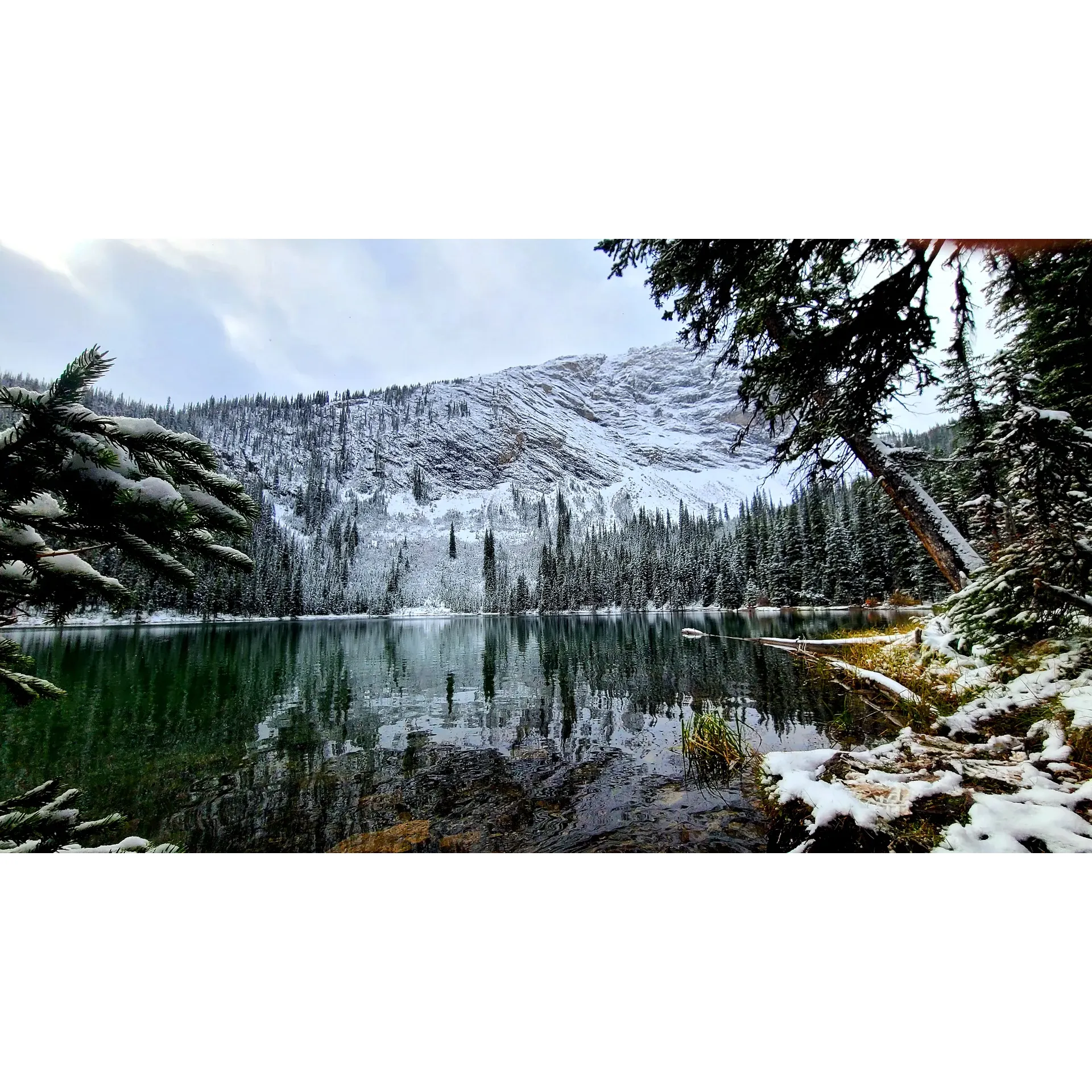 Discover the tranquility and adventure at Lillian Lake Backcountry, a prime destination for outdoor enthusiasts and a jewel of the Kananaskis area. Embrace the rewarding experience with a moderate hike that offers varying challenges suitable for both beginners and experienced backpackers. Expect roughly a 6 to 7-kilometer trail that will take approximately 2.5 hours to ascend, depending on your pace, but rest assured that the path is easy to follow, punctuated with sturdy wooden and metal bridges that span across serene water bodies.

The breathtaking scenery at Lillian Lake Backcountry captivates with its stunning vistas and clear, inviting waters, making it a picturesque spot for fishing and camping. Here, you can immerse yourself in the beauty of nature, whether during the lush summer months or against the backdrop of a sparkling, snow-covered landscape in the winter. 

Visitors are greeted with the exceptional warmth and camaraderie of fellow adventurers. Engage in delightful conversations by the campfire, where wood is conveniently flown in, creating a sense of community amidst the wilderness. The region's well-maintained facilities, including clean outhouses courtesy of dedicated park crews, enhance the camping experience, allowing you to focus on the natural surroundings and your outdoor pursuits.

As you explore, keep your eyes peeled for local wildlife, including the majestic black bears that roam the area, adding an element of awe to your adventure. While the lake itself invites some to take a refreshing swim, it remains a serene and undisturbed sanctuary for many others.

Plan an early arrival to secure your spot, as the allure of Lillian Lake Backcountry's stunning views tends to draw crowds, and the parking lot fills up quick. Remember to keep your dogs on a leash and prepare for an extraordinary journey that will surely call you back to its shores season after season. Whether you are casting a line into the crystalline waters, pitching a tent under the starry skies, or simply taking in the panoramic splendor, Lillian Lake Backcountry promises an unforgettable escape into the heart of nature's grandeur. Description by ChatGPT.