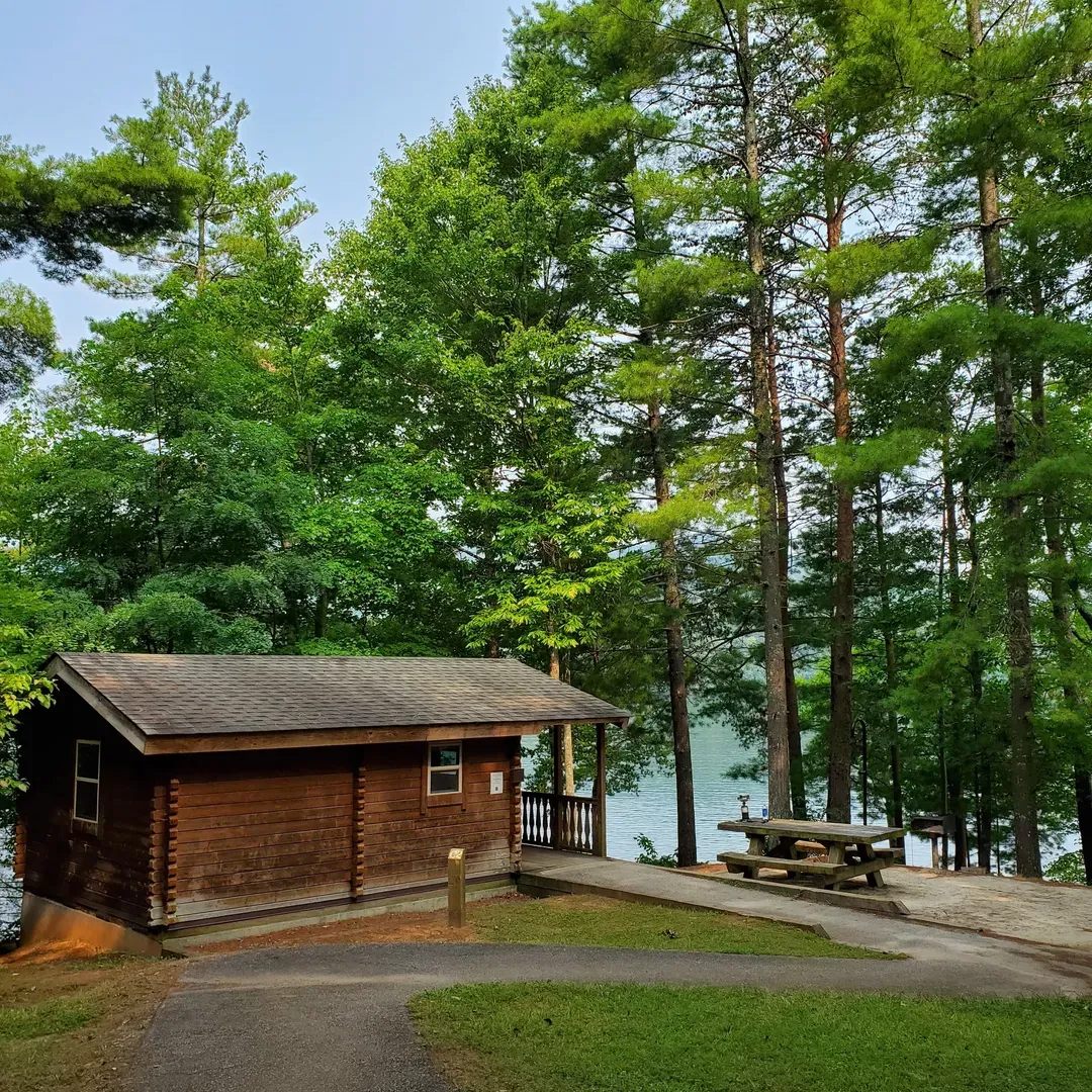 Cheoah Point Campground, located in the Cheoah Ranger District of Nantahala National Forest, presents an idyllic retreat for nature lovers and outdoor enthusiasts alike. This serene campground offers well-maintained facilities amidst the splendor of the surrounding forest and the shimmering waters of Lake Santeetlah. With multiple clean and plentiful bathrooms, campsites equipped with essentials like fresh water faucets, and the option for 50 amp electric hook-ups, visitors can enjoy a comfortable stay with some of the conveniences of home.

The proximity to Robbinsville ensures ease of access to local amenities, allowing guests to replenish supplies within a brief 10-minute drive. Adventure seekers can indulge in a variety of recreational activities such as kayaking from convenient water access points, which for some sites appear as their own secluded cove. Anglers can while away the hours in their quest for trout, adding a touch of excitement to their peaceful surroundings.

The area is a paradise for motorcyclists, offering breathtaking rides, with popular routes like the Tail of the Dragon and Cherohala Skyway nearby. Meanwhile, hiking enthusiasts can explore local trails leading to stunning waterfalls, such as Yellow Falls Creek, only a short distance away.

Camp sites are generously spaced to ensure privacy, and first-come, first-serve spots like the coveted site 17 provide exceptional views and a sense of personal seclusion. The campground's knowledgeable host maintains a watchful and caring presence, while free hot showers and the lack of crowding, particularly outside peak season, contribute to an aurora of relaxation and tranquility. Whether visitors seek days filled with activities or a quiet place to unwind, Cheoah Point Campground is an unforgettable destination that combines natural beauty, outdoor fun, and coziness in the heart of a pristine national forest. Description by ChatGPT.