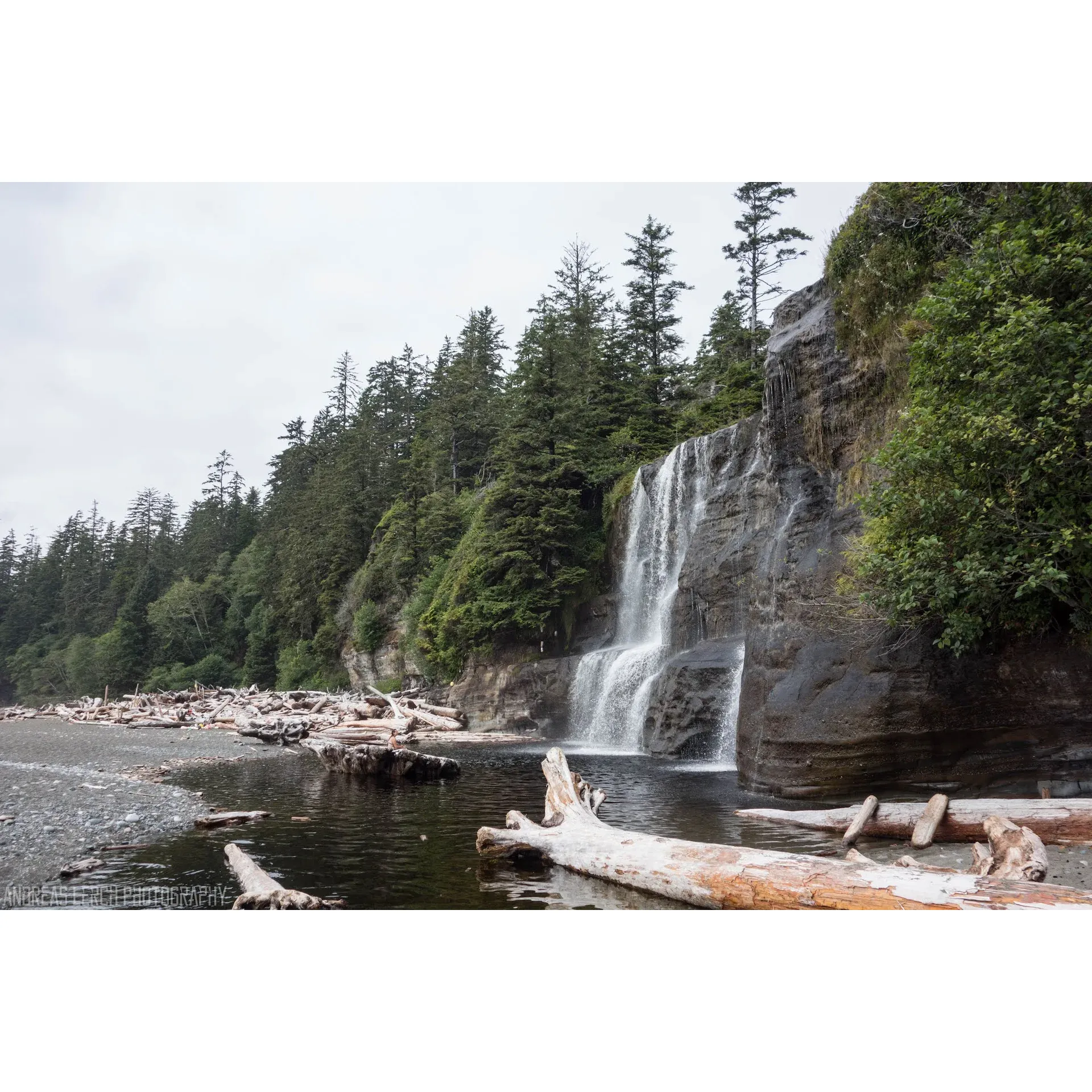 Tsusiat Falls offers a picturesque and thrilling adventure for outdoor enthusiasts seeking a unique camping and swimming experience. Crystal-clear waters cascading into an inviting pool make for a refreshing and rejuvenating natural shower, complemented by the serenity of the surrounding wilderness. The area boasts a scenic campground that complements the natural beauty of the falls, where campers can feel the embrace of the wilderness.

Even on days touched by rain, the falls provide a sense of adventure and refuge, allowing visitors to discover warmth and comfort by sheltering in nearby caves and enjoying the ambient warmth of a campfire. The falls' temperate waters invite for a revitalizing swim, offering a memorable experience regardless of the weather.

While the journey to this natural wonder includes an exhilarating descent down a series of ladders, the reward is a stunning beachfront view of the waterfall, which serves as a backdrop for a picturesque setting that captivates all who visit. Tsusiat Falls is not only a destination for its captivating scenery but also a vital water source for those exploring its beauty.

Enthusiastic visitors rave about the site’s charm and are eager to return, finding the opportunity for a quick dip and access to fresh water irresistible. Tsusiat Falls remains etched in the memories of visitors as a must-visit location where nature's bounty is enjoyed in its purest form. Description by ChatGPT.