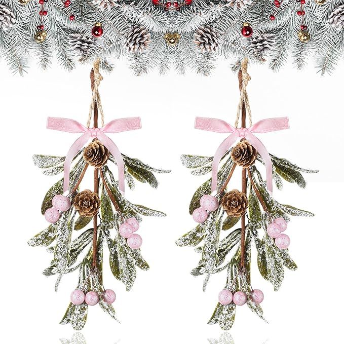 Add a touch of festive cheer to your holiday decor with this set of 2 artificial mistletoe hanging ornaments. Each pick features pale green leaves, pink berries, natural pine cones, and fake snowflakes, all tied together with a pink bow for a delicate and beautiful look.