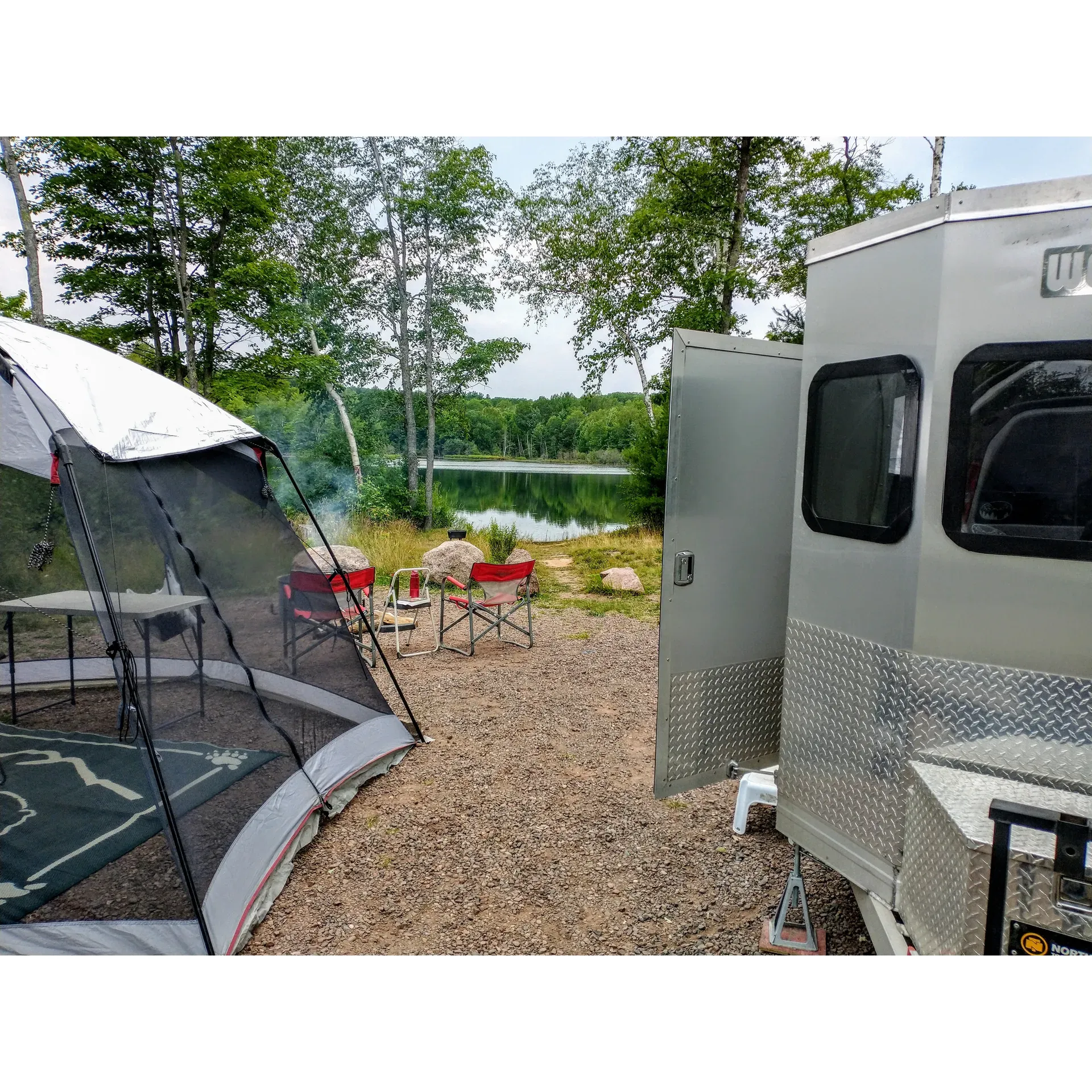 Set in the embrace of a tranquil forest landscape, Birch Grove Campground offers a serene escape for outdoor enthusiasts. The campground boasts dual picturesque lakefronts ideal for kayaking and gentle boating, with convenient basic boat landings at each body of water. The lakes' serene waters reflect the surrounding beauty and beckon paddlers to explore their calm expanse.

Though the waters proximal to the campground may not be best suited for swimming, visitors will find solace in a small, charming beach along the western lake, perfect for relaxing with a book or enjoying the sun's warmth. For those seeking a refreshing dip, a beautiful swimming beach alongside a scenic hiking trail awaits at nearby Long Lake—a haven for swimmers and nature lovers alike, easily accessible via a short drive or invigorating bike ride through the undulating landscape.

The campground's facilities, while rustic, are maintained with the utmost care—visitors will find spotless pit toilets and a water pump on-site contributing to a comfortable stay. Those who appreciate the simpler side of camping will revel in the absence of electricity, which ensures a truly authentic and peaceful experience. The natural surroundings provide large, comfortable campsites complete with new level gravel pads, fire pits, and picnic tables, making each spot an inviting home base for your wilderness adventure.

Adventure-seekers with a penchant for off-road excitement will find Birch Grove Campground to be an optimal destination, with trail access that promises exhilarating four-wheeling expeditions. Moreover, the campground's thoughtful additions of an extra outhouse and additional sites cater to the convenience of its patrons.

Nature's recovery from past storms can be seen in the burgeoning growth, promising future seclusion and beauty as the landscape heals and new vegetation thrives. Botanical wonders abound in the area, with raspberry, blueberry, and wild strawberry plants dotting the environs—a delight for foragers and nature enthusiasts.

Connectivity-wise, the campground surprisingly offers better phone signal than nearby towns, ensuring that guests can remain connected, should they choose to do so. Meanwhile, the absence of artificial lights entwines visitors with the nocturnal wilderness, allowing for unobstructed stargazing.

Indeed, Birch Grove Campground is a cherished refuge, providing both the solitude one seeks from a remote outdoor retreat and the facilities necessary for a comfortable and memorable stay. Whether you arrive prepared for minimalism or bring along a few modern conveniences like a generator, this campground serves as a beautiful and accommodating backdrop for your woodland adventure. Description by ChatGPT.