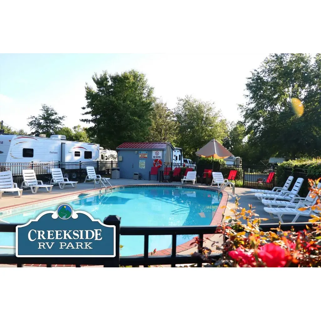 Creekside RV Park, acclaimed as one of the premier campgrounds in East Tennessee, provides a blend of exceptional service and tranquil ambiance, appealing to seasoned and new travelers alike. The family-owned and operated establishment prides itself on providing a timeless camping experience where guests feel appreciated, reminiscent of the golden era of the 70s when customer care was paramount.

Upon arrival, you are greeted by a welcoming and accommodating staff, eager to assist you in navigating any issues and offering their help to perfectly sit your unit, ensuring a seamless start to your stay. Comfort and convenience are at the forefront, with the park boasting meticulously clean facilities, including bathrooms, showers, and a well-equipped laundromat, alongside an efficient trolley service that provides easy access to local attractions, making your exploration of the scenic locale hassle-free.

Campers can unwind in the serenity of Creekside RV Park, where sites like 102 allow you to delight in the soothing sounds of a creek running gently behind your resting space. The park’s layout emphasizes both intimacy and community with strategically placed gravel sites complemented by concrete patio pads, some of which are pull-through for additional convenience. Group travelers find their needs tactfully accommodated, with the staff skillfully arranging adjacent sites for fellow campers, an attribute that is particularly appreciated among those traveling with different types of camping units.

Strategically located, the park offers the perfect balance between peace and proximity. It’s a peaceful oasis just a stone’s throw away from the excitement of Pigeon Forge and Gatlinburg. This positioning means that while nestled in the quiet embrace of the park, all the attractions and amenities of the surrounding area are just a brief journey away, ensuring the best of both worlds.

Creekside RV Park stands out for its cleanliness, maintenance, and overall dedication to providing the best value and experience to its visitors. With its scenic setting, attentive staff, and emphasis on a sterling visitor experience, this RV park continually earns glowing recommendations and repeat visits from contented campers looking forward to their next peaceful retreat. Description by ChatGPT.