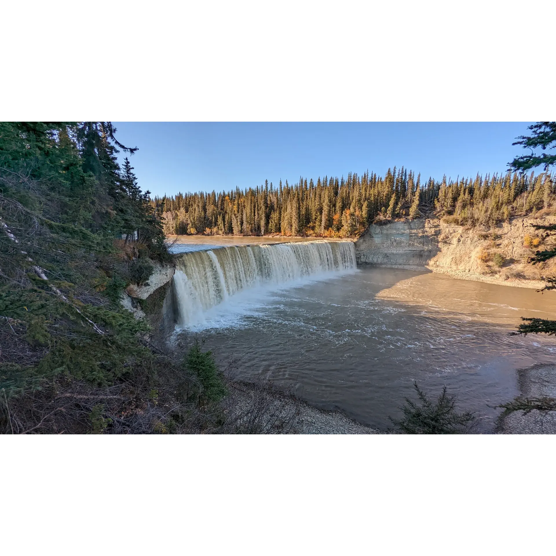 Surrounded by the tranquility of nature, Lady Evelyn Falls offers a delightful escape for both the adventurous soul and those seeking a peaceful retreat. With its captivating waterfall just a short and easy distance from the highway, visitors can immerse themselves in the beauty of the Northwest Territories without straying too far from their route. The falls themselves are a sight to behold presenting a stunning display of cascading waters that have enchanted many travelers.

The well-maintained campground provides visitors with a serene place to stay, complete with ample space ensuring privacy and quietude. Coupled with the admirable dedication of the campground host, guests are sure to experience exceptional hospitality and a warm welcome. With each campsite generously laid out, guests can revel in their own exclusive spot to unwind or gather around a campfire with loved ones.

The tranquility of the park offers an ideal setting for a soothing night's rest or contemplation to the soothing sounds of nature. The standard facilities, practical and clean, cater to the needs of all campers, ensuring a comfortable stay amidst the great outdoors.

Whether stopping by for a brief interlude during a long drive or setting up camp for a longer stay, Lady Evelyn Falls is a beloved gem. Visitors are encouraged to come prepared with bug spray and mosquito nets to fully enjoy the remarkable outdoors experience offered here. A pause at these falls is not just about the journey, but about creating moments of beauty and peace, with the gentle murmur of water as the perfect backdrop. Lady Evelyn Falls is indeed one of the great wonders of the Northwest Territories, beckoning travelers with its natural charm and soothing ambiance. Description by ChatGPT.