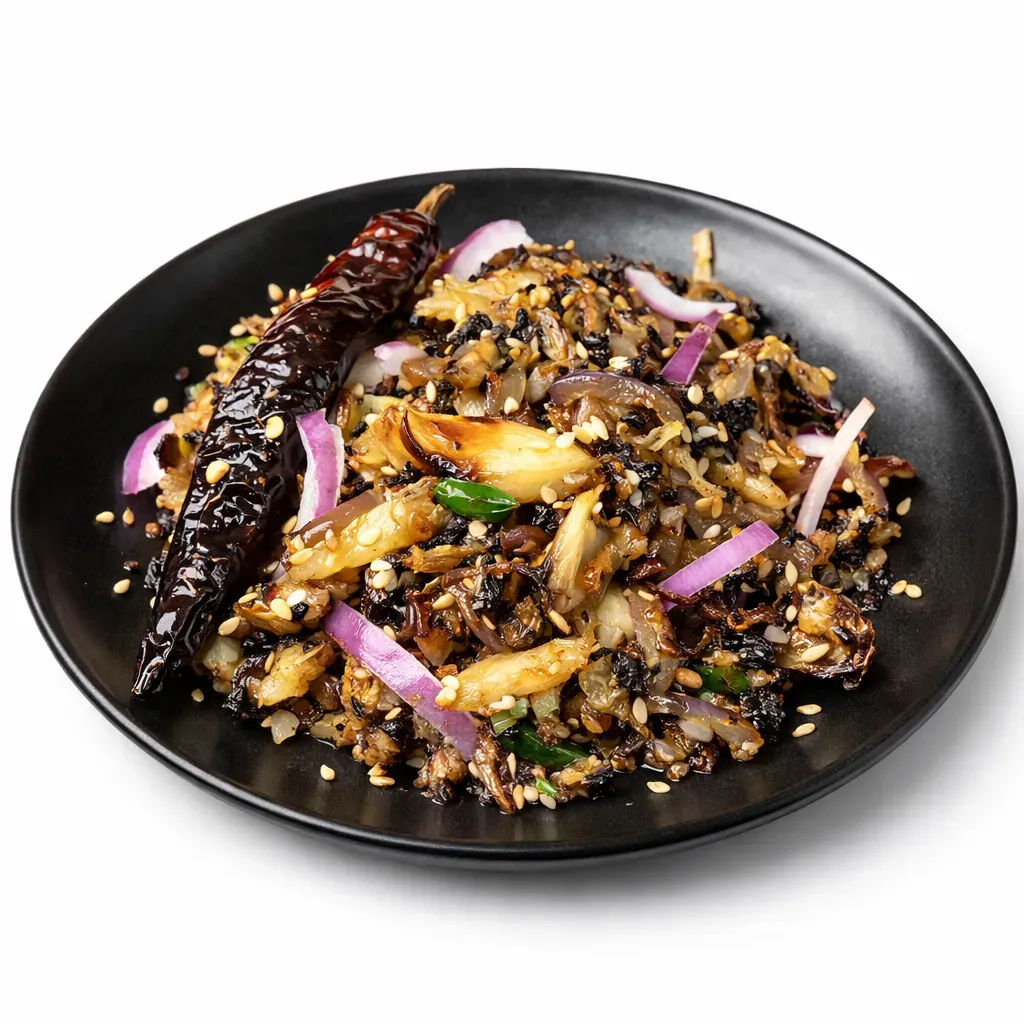 A traditional Bengali dish featuring roasted garlic mashed with caramelized onions, chilies, and sesame seeds, perfect as a side for hot rice.