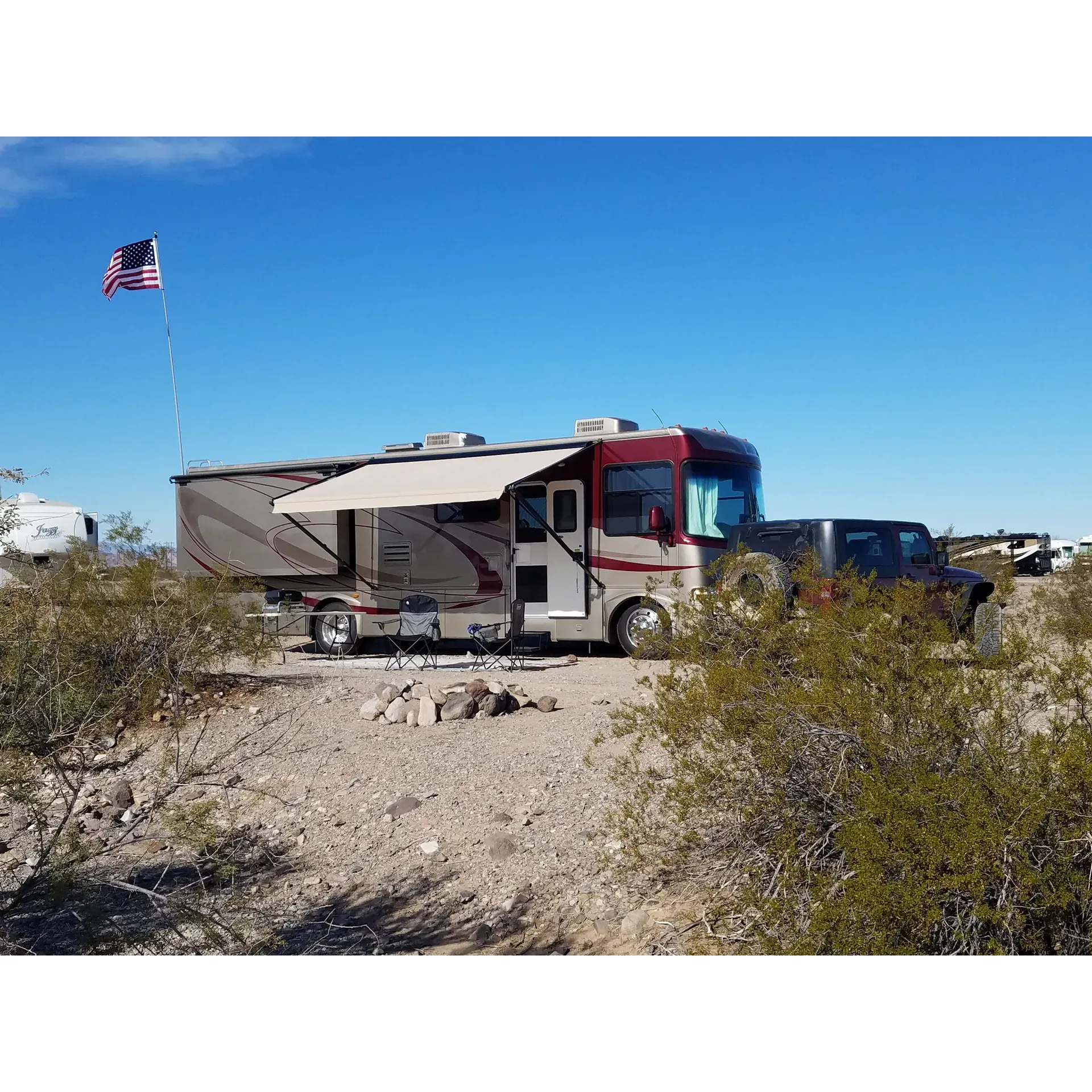 Hi Jolly Campground emerges as a serene retreat for nature enthusiasts and those seeking the tranquility of the desert. With its spacious layout, the campground offers plenty of room for RVs of any size, ensuring easy parking and hassle-free stays for all guests. Its location, a mere 3 miles north of Quartzsite, presents the perfect balance of solitude and convenience, with the charming town nearby for any essentials.

Highlighting the natural beauty of the area, visitors are treated to breathtaking views of the desert landscape and the encompassing mountains, creating an idyllic backdrop for both day and adventure seekers alike. The large, Bureau of Land Management (BLM) designated area provides a hub for off-grid camping experiences, where the lack of facilities encourages a genuine connection with the pristine environment and self-sufficiency.

Guests at Hi Jolly Campground revel in the profound peace and quietude it offers. The absence of crowds and noise pollution allows for an intimate encounter with nature, where one can fully immerish in the desert’s allure. The clear, beautiful night sky sparkles above, offering stellar stargazing opportunities that are bound to leave a lasting impression.

For those looking for a temporary desert domicile, Hi Jolly Campground extends a warm welcome with a generous 14-day stay limit at no cost. Though amenities are not provided, the availability of small fire pits and a clean environment ensures a comfortable and authentic camping experience. Moreover, the presence of a camp host to assist with registration adds an extra layer of security and community feel to the site.

Seasoned travelers and solo adventurers alike find solace in this remote getaway, where the simplicity of the surroundings fosters a restful escape. Hi Jolly Campground stands out as a favorite pit-stop and a safe haven in the midst of the Arizona countryside. Whether it's for overnight lodging or an extended desert sojourn, the campground promises a quiet refuge where the spirit of outdoor adventure thrives. Description by ChatGPT.