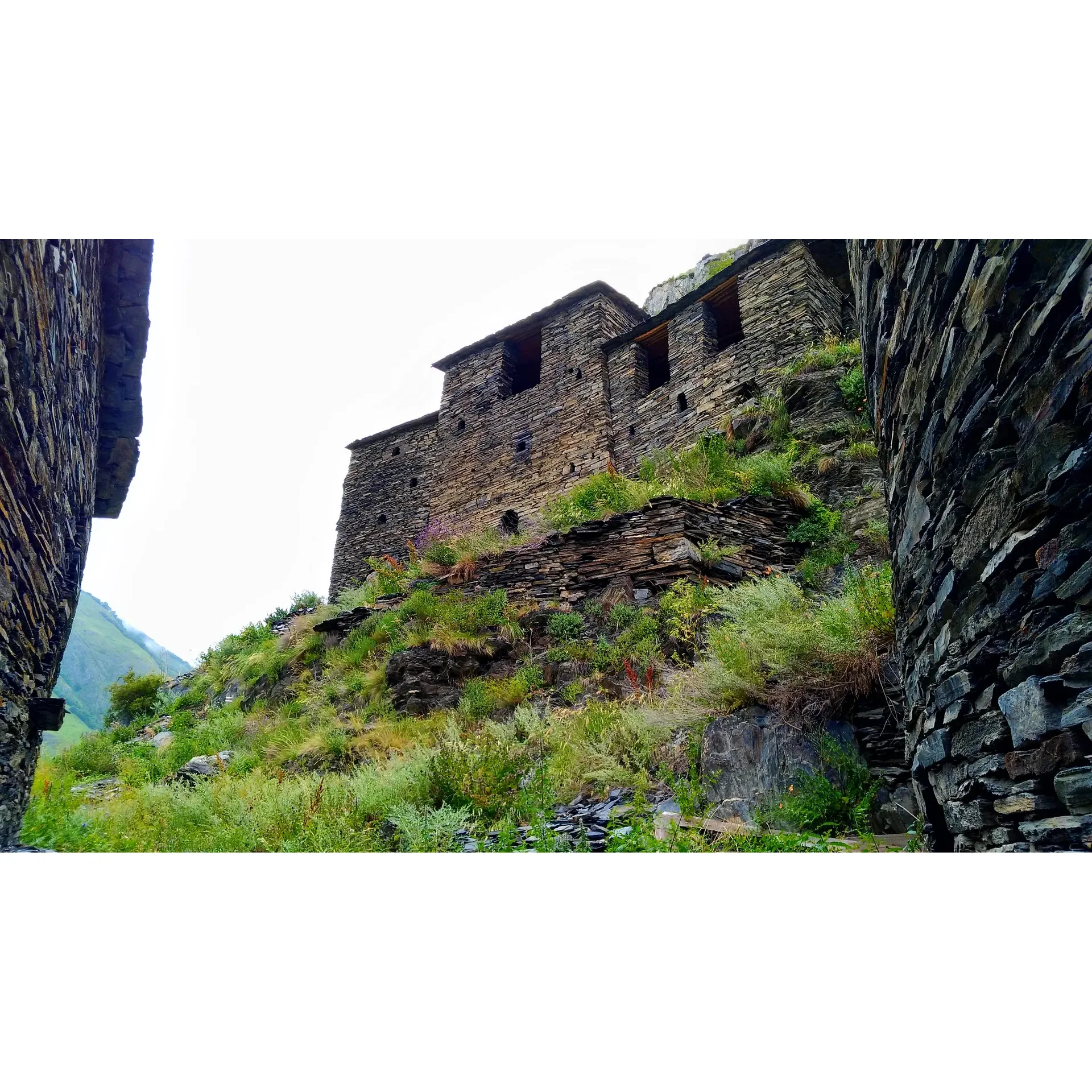 Mutso is a medieval fortress village located in the historic region of Khevsureti, in the mountains of Georgia. It is perched on a rocky hillside overlooking the Andaki river valley, surrounded by stunning natural scenery. Mutso is known for its unique stone towers, many of which date back to the 9th-14th centuries, making it one of the oldest and most well-preserved fortress villages in the country.

The village of Mutso has a long and storied history, with legends of its origins dating back to the 4th century. It was once a strategic stronghold, providing protection to the surrounding region against invading forces. Today, Mutso is a popular tourist destination, attracting visitors with its picturesque setting, ancient architecture, and rich cultural heritage.

Visitors to Mutso can explore the narrow cobblestone streets, climb the centuries-old towers for panoramic views, and learn about the history and traditions of the village from local guides. The village has been designated as a UNESCO World Heritage Site, recognizing its importance as a cultural and historical landmark in Georgia. Description by ChatGPT.