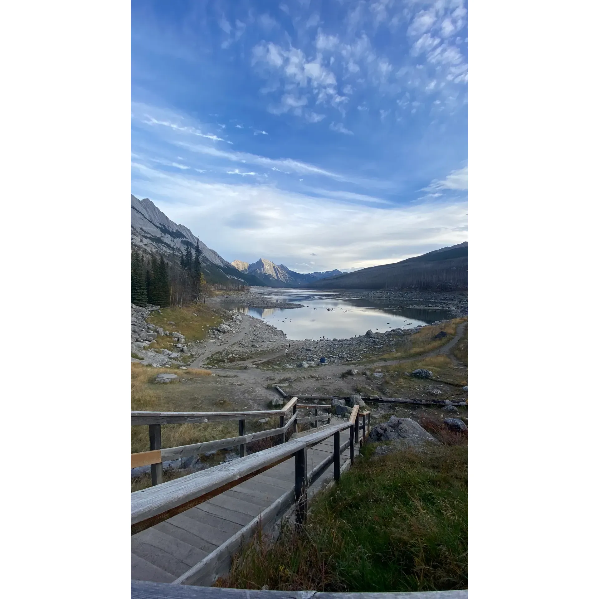 A spellbinding retreat that radiates tranquility, Medicine Lake is a jewel deep within the diverse wilderness of Jasper National Park. Embracing visitors with its crystal-clear waters mirrored by majestic mountains, the landscape around the lake seems to have leapt out of a painting, offering an array of photogenic vistas. Wildlife enthusiasts revel in the chance to spot an impressive tapestry of fauna, including elk, deer, bears, and moose, contributing to the enriching and authentic wilderness experience.

Glistening like a watery tapestry laid out amidst the sprawling peaks, the lake is more than just a body of water—it's an enigmatic geological wonder. The "disappearing" phenomenon creates a sense of intrigue, drawing curious minds to witness the astonishing natural spectacle as waters vanish and reemerge with the seasons.

Adventure seekers and serenity searchers alike will find solace in the numerous trails surrounding the lake—paths that invite exploration at a pace that suits any visitor. A hike around Medicine Lake offers an opportunity to engage with nature intimately, where reflections of the sky dance on water's surface and the regenerating flora signals Nature's enduring resilience.

Whether you arrive post snowstorm to witness the area's magnificent rebirth under a silver sun, or during the times when the lake reverts to a mere river, the magic of the location is unwavering. Medicine Lake's divinity in scenery and spirit makes it more than just a destination; it's an encounter with the sublime, promising indelible impressions of its resplendent and divine beauty. Description by ChatGPT.