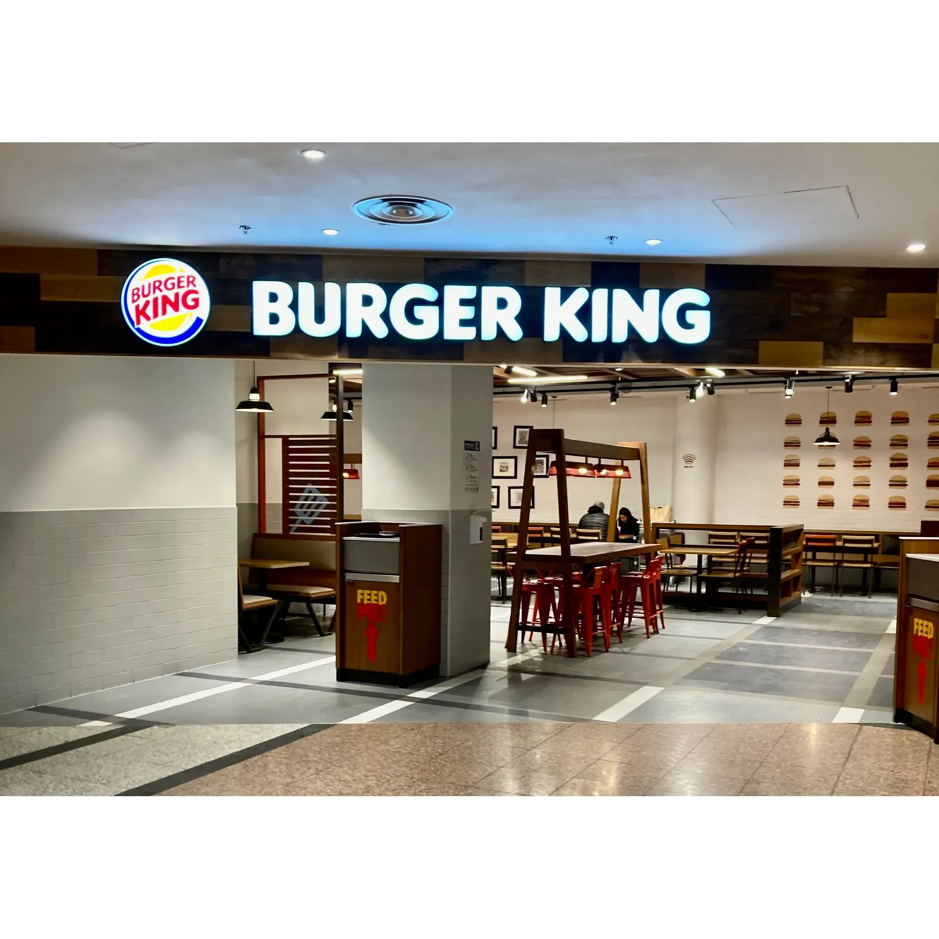 Indulge in the classic taste of Burger King's signature offerings as you traverse through Terminal 1. As a coveted pit stop for travelers with discerning palates, Burger King presents the illustrious Whopper, enhanced with cheese and bacon, celebrated for its juicy perfection and satisfying moist texture that burger aficionados crave. Complementing this iconic burger are the freshly-prepared, golden fries, known for their crispness and a delightful crunch with every bite.

While exploring the variety of their menu, you may come across the unique crunch wrap-like burger – a testament to Burger King's commitment to innovation and offering unique twists to familiar favorites. Customers have noted the convenience of Burger King’s modern ordering systems, with self-service kiosks streamlining the process and minimizing wait times.

As you prepare for your journey or simply await your next flight, the convenience of ample seating and easy access to charging outlets in this eatery provides a comfortable and efficient environment for both dining and productivity. Burger King at this location is tailored to the needs of international travelers, making it an easy, pleasant reprieve from the hustle and bustle of travel. 

Embracing the era of connectivity, Burger King understands customers' needs for reliable internet access and aligns with the swift free WiFi service provided by the airport, ensuring that you stay connected with ease as you enjoy your meal. Whether you're in search of a satisfying classic or a hot, crispy side, Burger King in Terminal 1 stands ready to enhance your travel experience with their characteristic offerings. Description by ChatGPT.