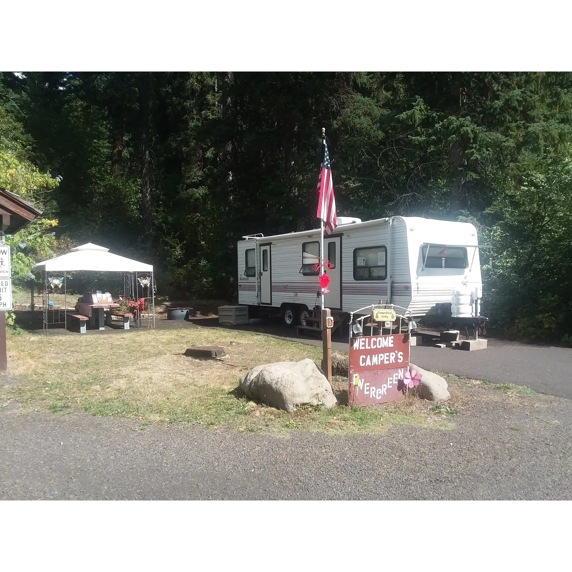 Evergreen Picnic Site and Campground emerges as an idyllic outdoor retreat offering an immersion into the tranquility of nature, complete with the serene soundtrack of a cool, nearby creek. Revered for its impeccable cleanliness, the campground invites nature enthusiasts to enjoy a pristine environment that promotes peaceful relaxation and outdoor enjoyment.

The accommodations present a harmonious balance of privacy and accessibility, with sites thoughtfully arrayed to afford visitors their own secluded haven amid the natural surroundings. Every camping spot, whether meant for RVs or tents, is meticulously maintained, boasting a graveled square area, a fire pit, and a picnic table, ideal for gathering around a warm flame to roast marshmallows or share stories.

RV travelers will find the paved sites to be accommodating, catering to smaller to mid-size rigs (up to 30ft including the tow vehicle), ensuring a harmonious fit within the lush wooded camp area. While the campground is conveniently positioned, the well-planned site placement further from the highway allows for a tranquil retreat without the distraction of road noise.

For those who prefer traditional camping methods, tent sites offer a vibrant connection to the surrounding environment, allowing for an authentic and memorable outdoor experience. The campground maintains essential facilities for a comfortable stay, including hand pump water and a couple of vault toilets, ensuring the basics are covered.

Adventure is never far off, as the campground provides direct access to the magnificent Weiser River Trail. Cyclists and walkers alike will find delight in exploring this scenic pathway, adorned with trees and charming bridges that traverse the flowing river.

Evergreen Picic Site and Campground is a cherished spot for a short stopover or a prolonged stay to disconnect from the digital realm and immerse oneself in nature's embrace, encouraging visitors to return time and again for its simple yet enriching offerings. Description by ChatGPT.