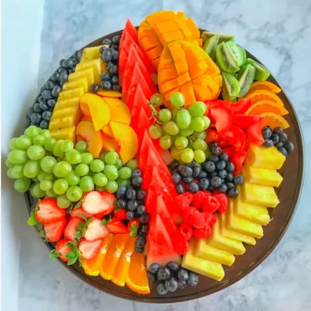 This vibrant fruit platter is a nutritious and visually stunning dish that's versatile enough to serve as a snack, appetizer, or dessert. Featuring an array of colorful fruits artfully arranged, it captures the freshness and sweetness of each ingredient, creating a feast for both the eyes and the palate.