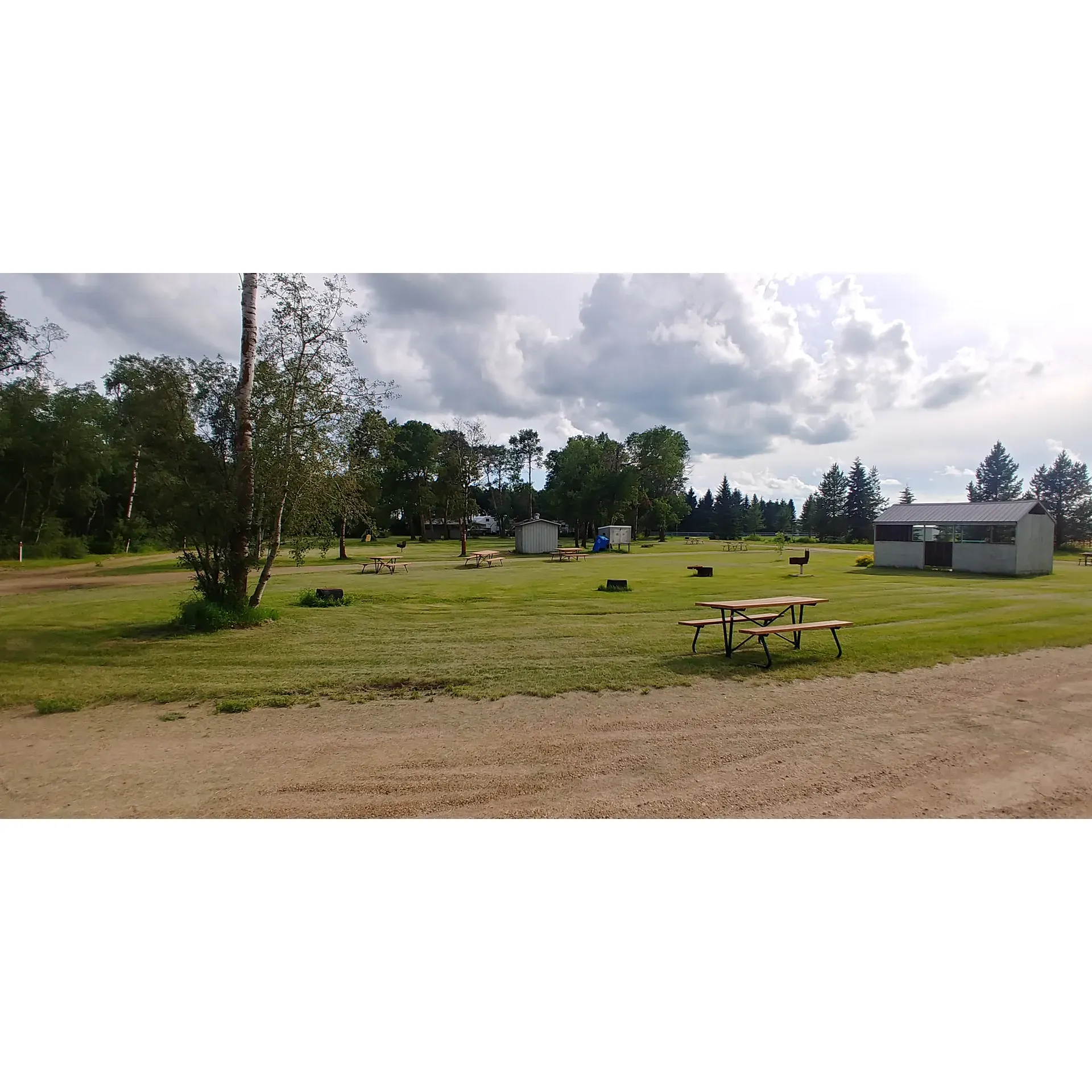 Bashaw Campground offers visitors an escape into the tranquility of the great outdoors with its variety of heavily treed sites, perfect for those seeking privacy and a close-to-nature experience. Ideal for weeklong stays or a peaceful stopover, guests revel in the serenity that pervades the location, especially during the quieter weekday getaways.

The self-serviced campground boasts very competitively priced sites at $20 per night with convenient self-registration, making it an affordable and uncomplicated retreat. Impressively maintained during the peak season, the campground's restrooms are often celebrated for their cleanliness—a commendable feature that attracts even those just passing through.

As a hub of activity during events at the neighboring Ag grounds, the campground also promises a lively atmosphere for those who enjoy a more social camping experience. For convenience, a trailer dump is available, although it operates on solar power, which may affect its occasional availability.

Families and casual visitors can take advantage of the charming playground and the sheltering structures useful for dining or gathering, particularly welcome in inclement weather. With its close proximity to Highway 53, the campsite provides easy access for travelers. Nightfall brings a hush over the campground as traffic lessens, allowing campers to settle into a calm, restful evening.

While services such as electrical hookups may not be available, the tranquil surroundings and the draw of disconnected, undisturbed nature more than compensate for the more rustic experience. Bashaw Campground is a favored spot by many who appreciate its simple offerings, clean facilities during peak times, and the allure of Alberta's beautiful outdoors. Whether passing through or seeking a charming spot for a camping vacation, Bashaw Campground promises a delightful experience for all who visit. Description by ChatGPT.