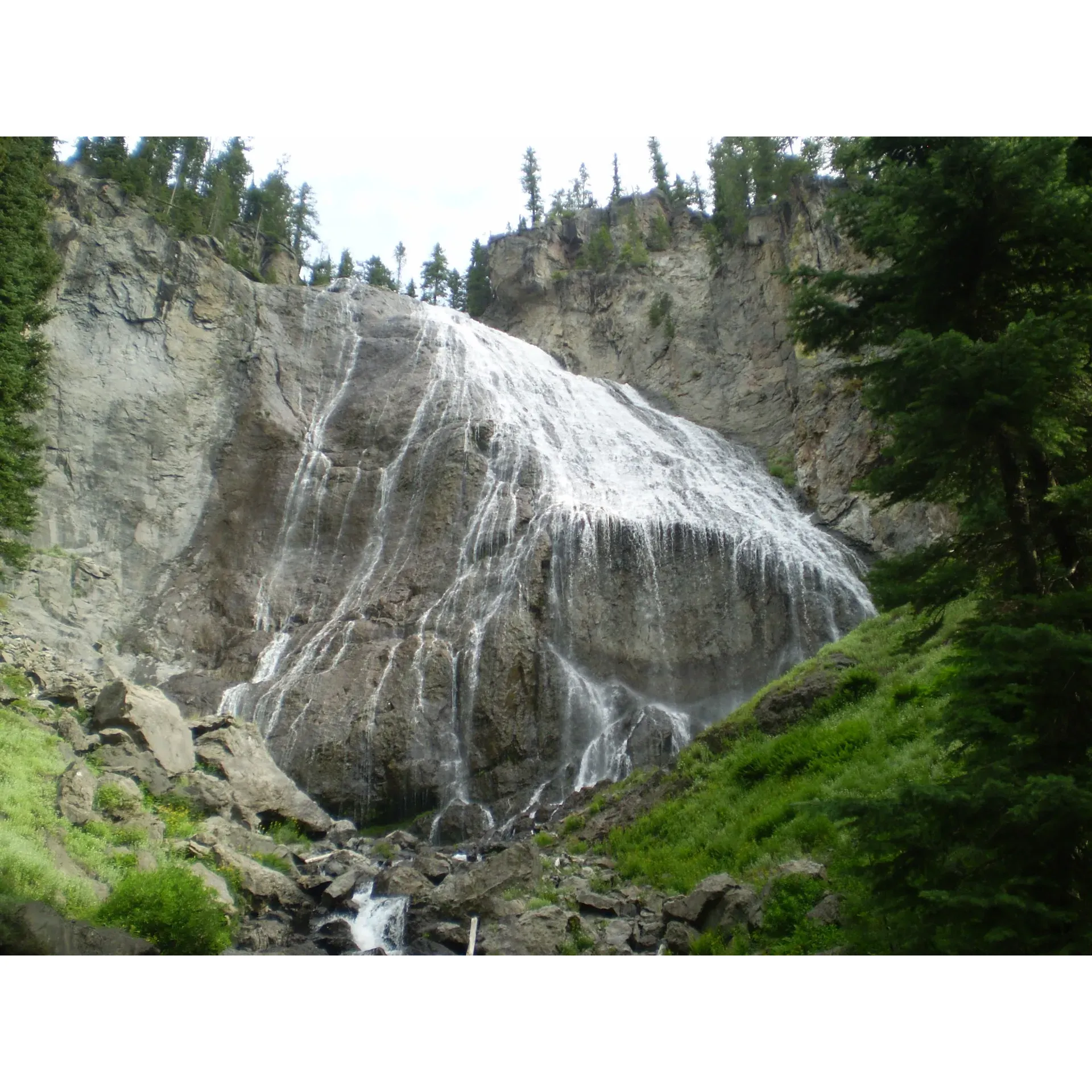 Ouzel Falls is a picturesque waterfall located in Yellowstone National Park, Wyoming. The falls are situated in the southwestern region of the park, near the Continental Divide Trail. The waterfall cascades down a rocky cliff face into a turquoise-hued pool below, creating a stunning and serene setting for visitors to enjoy.

Hiking to Ouzel Falls is a popular activity in Yellowstone National Park, with many visitors choosing to take the 2.7-mile round-trip trail that leads to the falls. The trail is relatively easy and well-maintained, making it accessible to hikers of all skill levels. Along the way, hikers will pass through lush forests and meadows, with the opportunity to spot wildlife such as elk, bison, and even bears.

Ouzel Falls is a perfect destination for nature lovers, offering a peaceful escape into the beauty of Yellowstone National Park. Visitors can relax by the waterfall, take in the stunning surroundings, and immerse themselves in the tranquility of the natural world. Whether you're looking for a leisurely stroll or a challenging hike, Ouzel Falls is a must-see destination for anyone exploring Yellowstone. Description by ChatGPT.