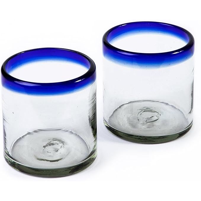 These 7 oz Hand Blown Mexican Drinking Glasses are crafted by artisans in Mexico and come in a set of 2. Each glass holds 7 fluid ounces of your favorite beverage and features a striking cobalt-blue rim. The hand-blown process creates unique imperfections and bubbles in the glass, giving each piece its own individual character.