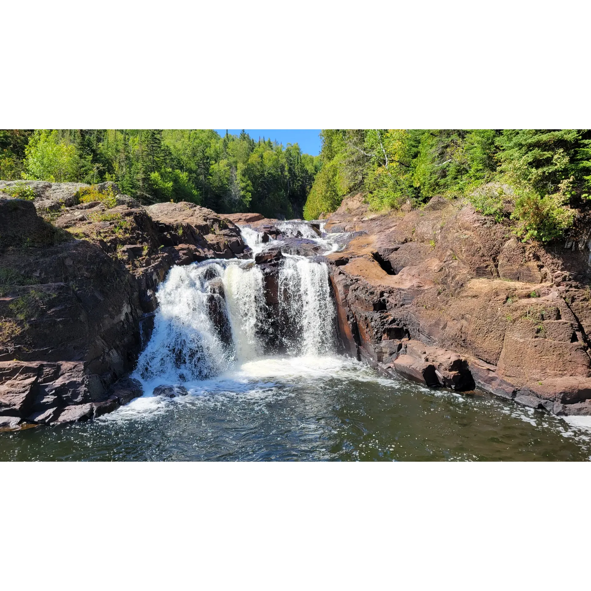 Judge C.R. Magney State Park is a captivating destination for those seeking an immersive outdoor experience. As a treasured slice of the North Shore, the park offers visitors an exceptional hiking journey leading to the intriguing phenomenon of Devil's Kettle. Along with being a draw for curious adventurers, the magnificent falls and the mesmerizing course of the Brule River astound all who witness their splendor.

The trails within the park, deemed an adventurer's delight, are lined with lush forests and traverse varied terrains offering breathtaking views. With an impressive array of hikes, from scenic to challenging, the park caters to a wide range of nature lovers. Enthusiastic hikers are especially fond of the rewarding vistas and the sense of achievement after conquering the stair-studded paths—be it the remarkable 283 steps one child joyfully counted or the upward climb that leads to Devil's Kettle.

Whether you're a seasoned explorer or a family looking for an engaging day trip, the park promises an unforgettable adventure with its panoramic river vistas and falls. Its prime location close to Grand Marais makes it a convenient escape to nature's splendor, providing a sense of seclusion without being too remote. The proximity to Lake Superior's rugged coastline further enhances the park's allure, presenting a picturesque backdrop for outdoor activities and moments of tranquility.

Emerging as a favorite among those seeking less crowded trails, Judge C.R. Magney State Park is not just an excursion but a destination where the beauty of Minnesota's wilderness is proudly on display. It invites visitors from all walks of life to discover its treasures, forge lasting memories, and witness the magic of the Great Outdoors. Description by ChatGPT.