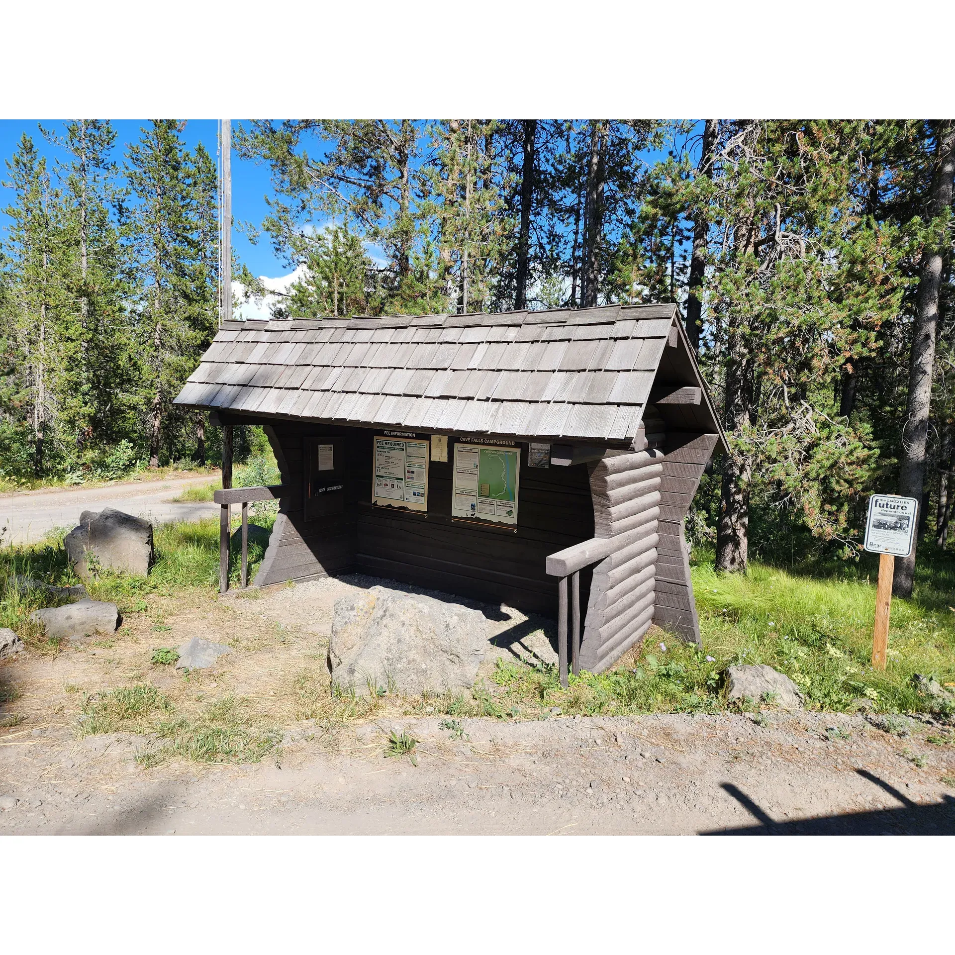 Cave Falls Campground is an idyllic retreat for visitors seeking an authentic outdoor experience in the splendor of West Yellowstone National Park. Offering a serene escape, this campground boasts pull-through sites that can accommodate even the most robust of camping setups, ensuring that every guest can immerse themselves in nature with ease. 

With each campsite offering a panoramic view of the nearby river, campers are invited to enjoy the scenic beauty and tranquil ambiance of the surroundings. The absence of electrical hookups enhances the rustic charm and encourages a return to the basics of camping, allowing for a deeper connection with the wilderness and a true off-the-grid adventure.

Despite its remote location, reached via an adventurous drive over long gravel roads, the payoff is a pristine, secluded environment that promises peace and quiet. The campground is an excellent base for even greater explorations, with nearby hiking trails leading to more stunning vistas of the falls, allowing nature enthusiasts to uncover the hidden treasures of the park at their own pace.

Meticulously maintained, the campground is celebrated for its cleanliness and calm atmosphere, providing a haven for those looking to relax and recharge. Visitors can take comfort in the thoughtfully laid-out sites where they can enjoy the picturesque setting and wildlife that frequent the area.

Overall, Cave Falls Campground delivers a sublime, undisturbed wilderness experience for those adventurers who appreciate the simplicity of nature, the joy of a secluded spot, and the allure of West Yellowstone's captivating landscapes. It offers a perfect day ride into the park and a splendid opportunity to create lasting memories beneath the open skies. Description by ChatGPT.