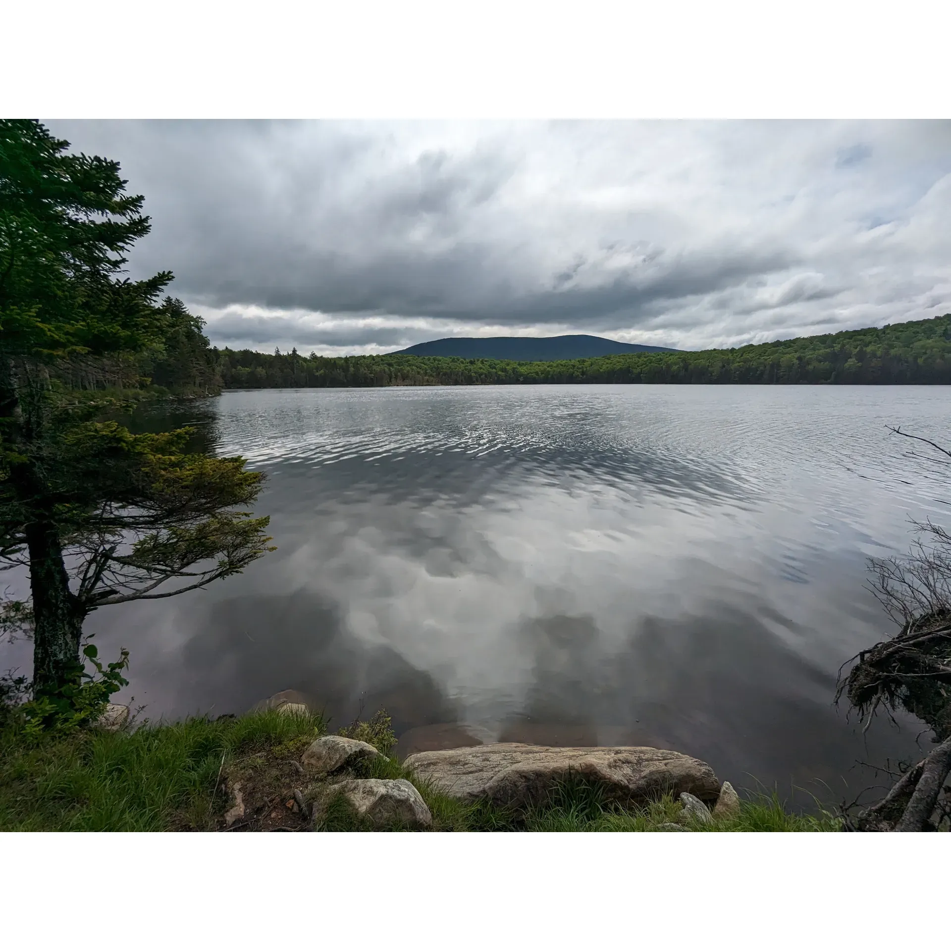 Stratton Pond Tenting Area is a charming and tranquil retreat for outdoor enthusiasts seeking a serene camping experience. Set by the picturesque Stratton Pond, the campground offers a harmonious blend of natural beauty and modern amenities for a comfortable wilderness escape. The area is currently enhanced by the addition of a lean-to under construction, promising additional shelter and convenience for future visitors.

The site takes pride in its environmentally conscious facilities, featuring a state-of-the-art moldering privy and a secure bear box, ensuring both cleanliness and safety for campers and the surrounding wildlife. Despite its modest size, the tenting area holds an allure for those who appreciate an intimate and peaceful setting. Guests can immerse themselves in the soothing sounds of nature as twilight unfolds, with birdsong and the gentle chorus of spring peepers lulling them to sleep.

The tenting area boasts an unmatched stillness, further elevated by the stunning trails leading to the campground, offering a visually delightful journey regardless of the chosen path. Its proximity to the lesser-traveled east side of Stratton Pond Shelter means that visitors are likely to relish a more secluded and quiet camping experience, just a stone's throw away from the well-known Appalachian and Long Trails.

Outdoor adventurers inclined towards exploring and creating memorable circuits will find Stratton Pond Tenting Area and the nearby Bourn Pond to be exceptional starting points. Whether one is aiming to conquer the adjacent Stratton Mountain or enjoy a pleasant out-and-back journey on trails 407, 431, or a left turn on trail 441, this camping spot serves as an ideal base. Here, each visitor is welcomed with the promise of natural simplicity and the subtle luxury of solitude amidst the beauty of Vermont's wilderness. Description by ChatGPT.